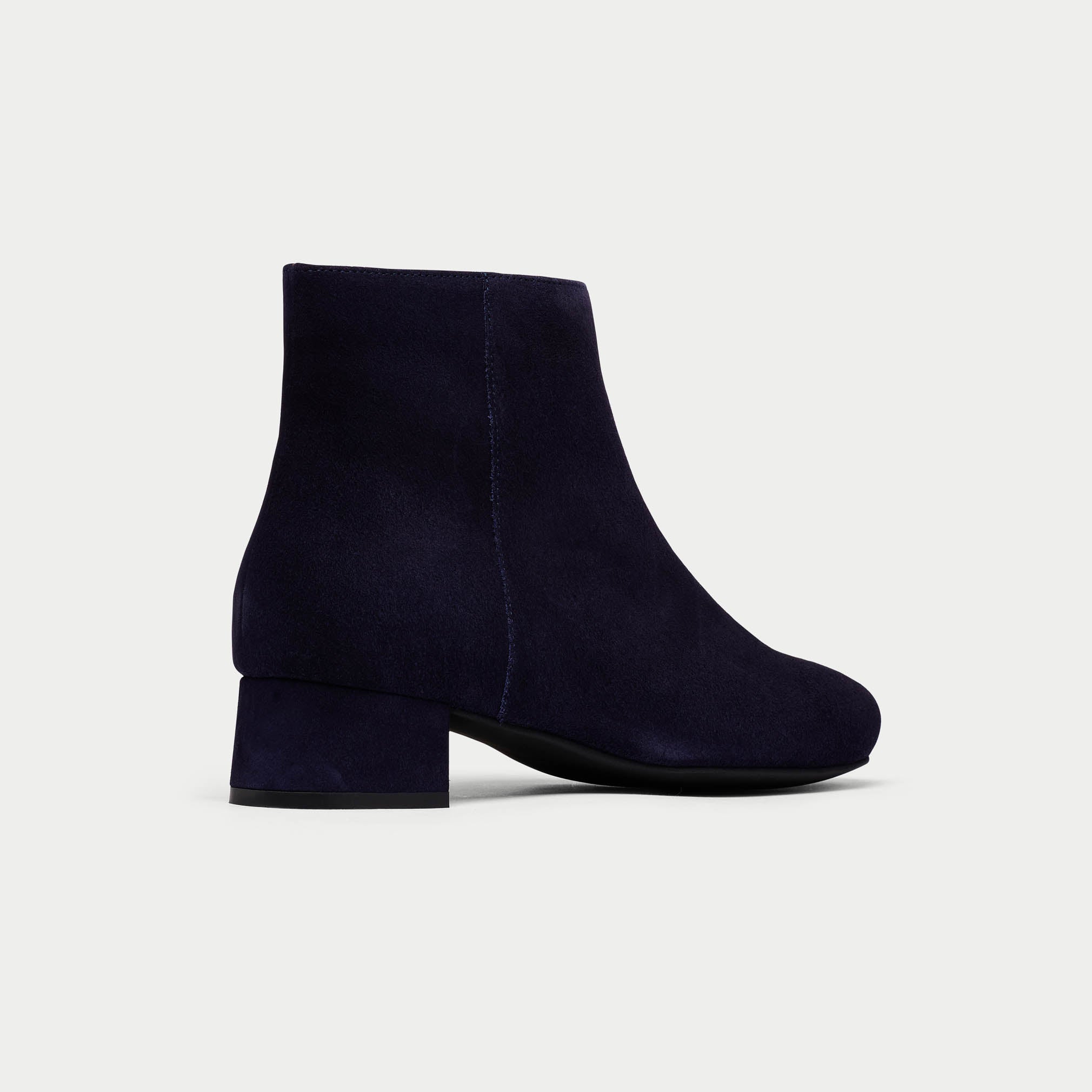 Navy blue ankle boot on a light gray background