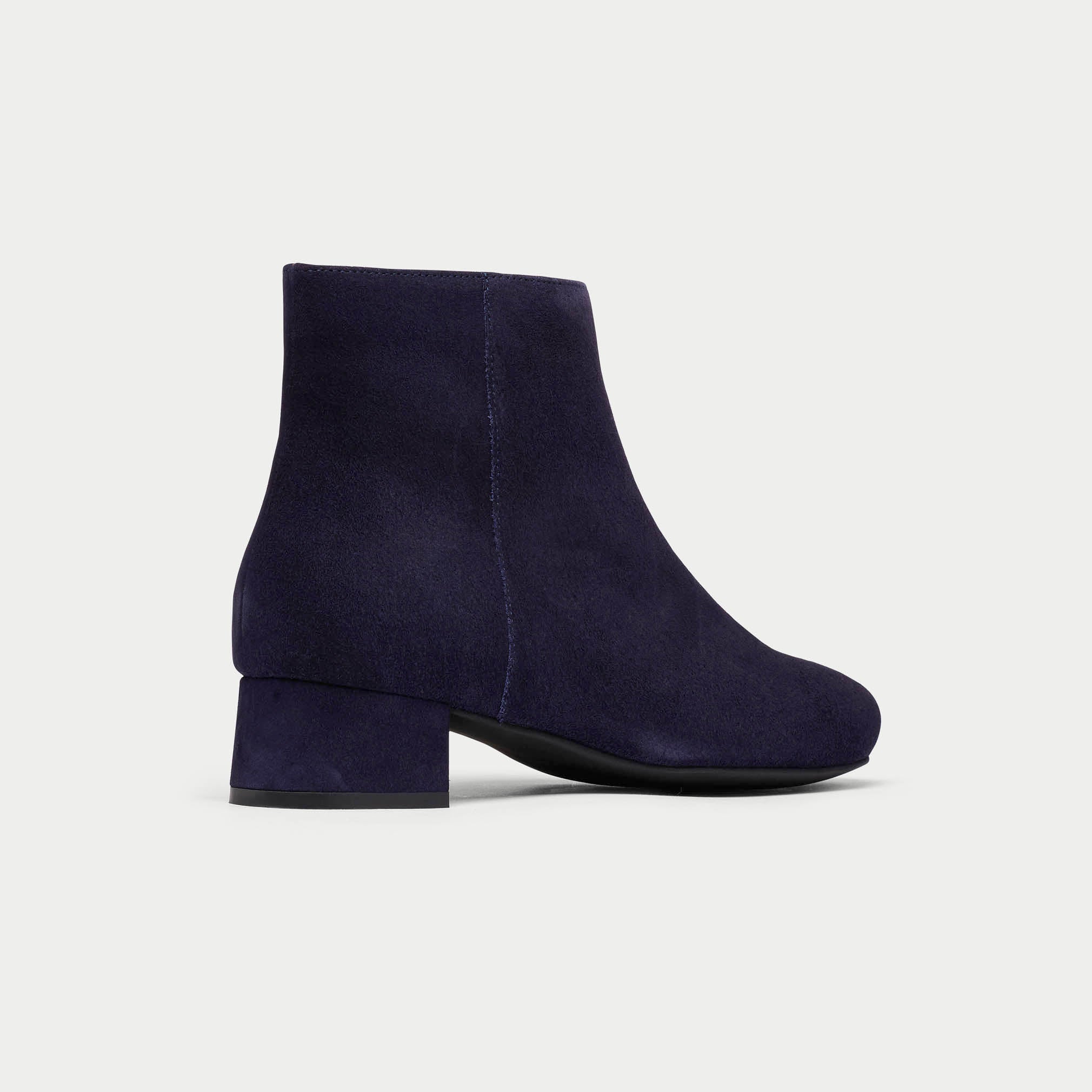 Navy blue ankle boot on a light gray background