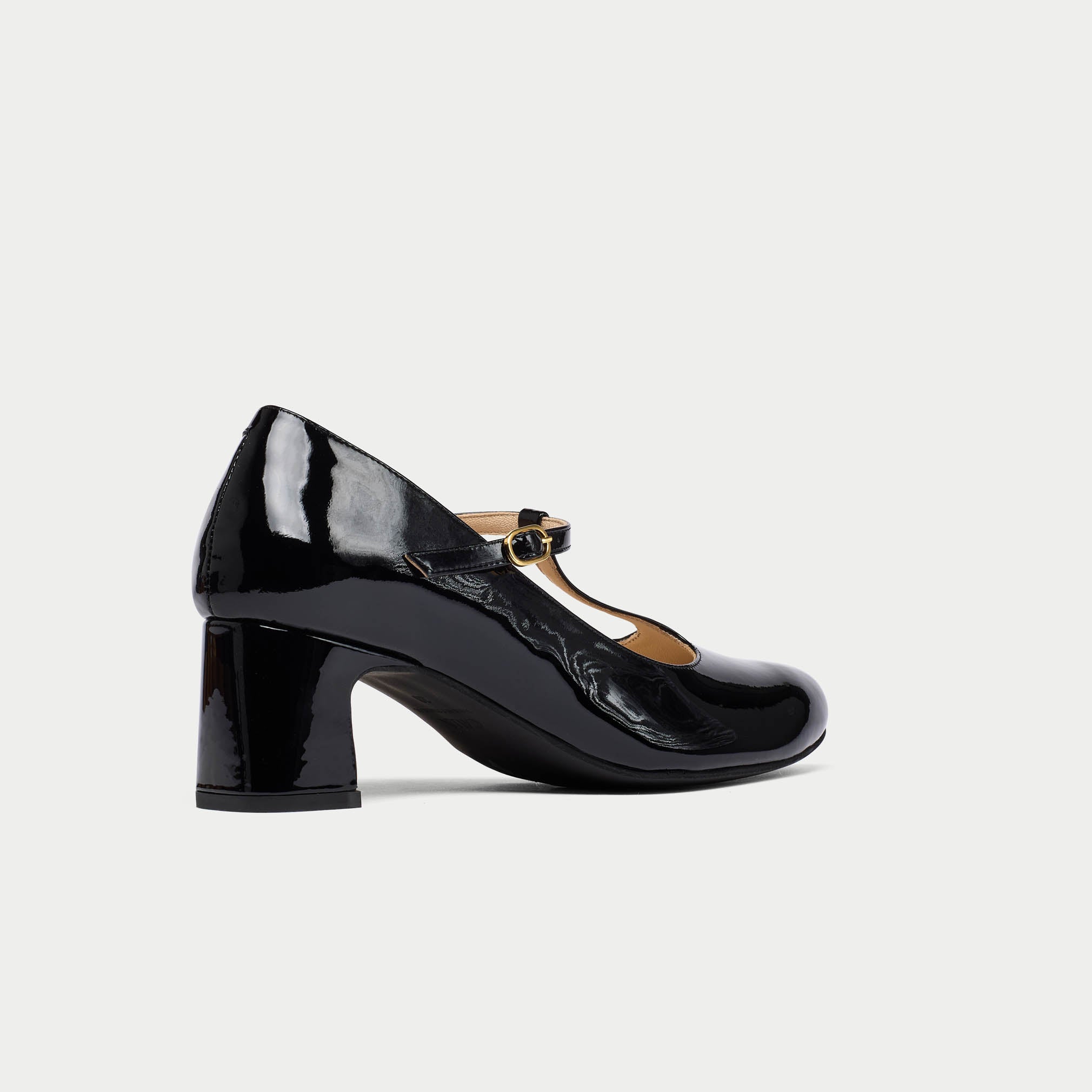 Black patent leather shoe with a block heel on a light gray background