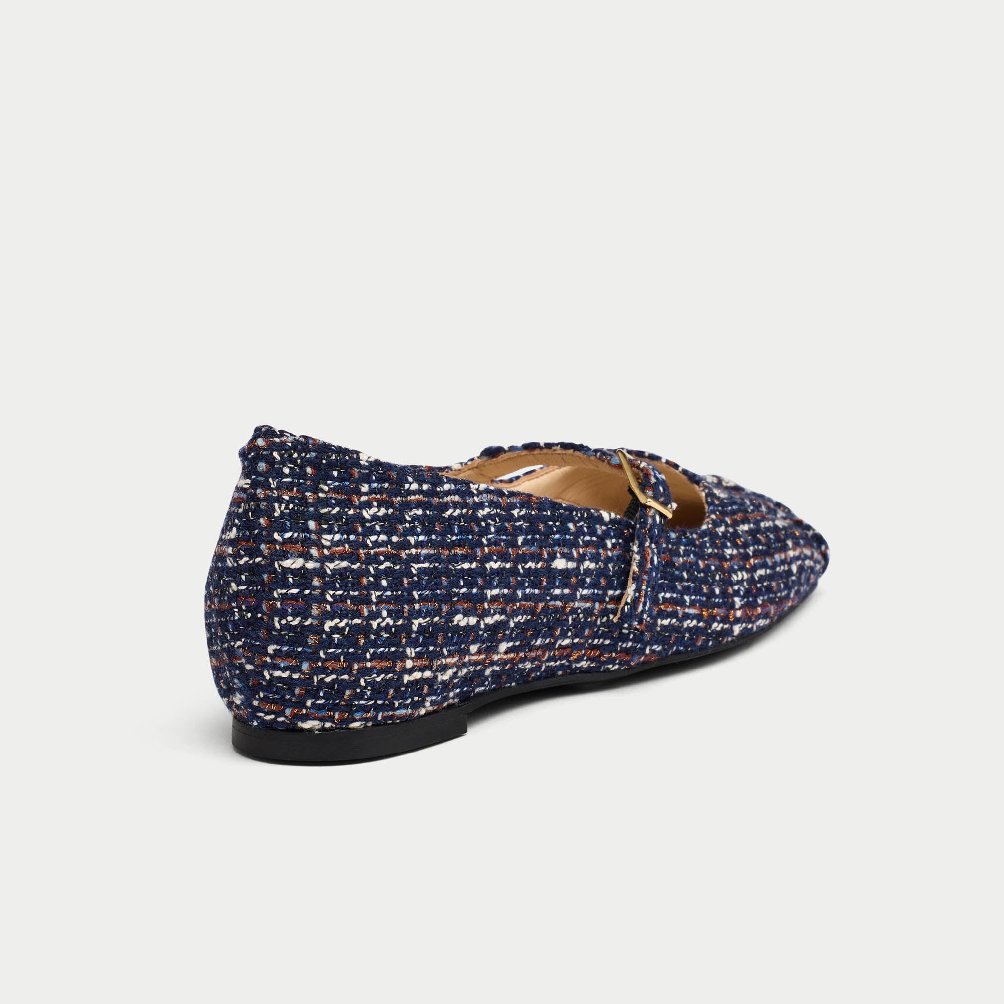 Blue tweed flat shoe with brown leather trim on a light gray background