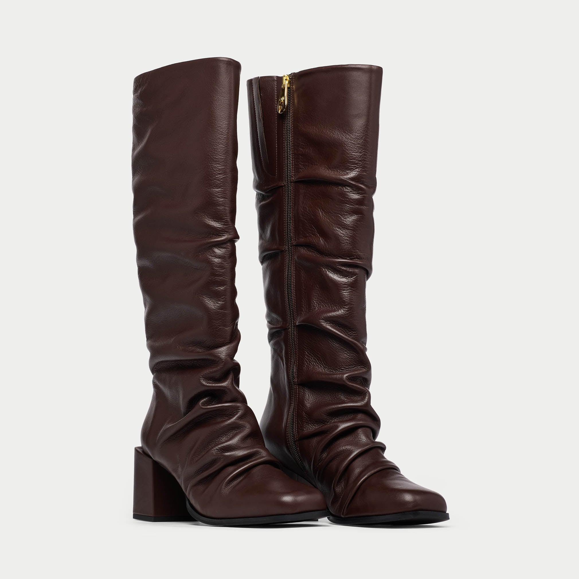 Pair of brown knee-high boots on a light gray background