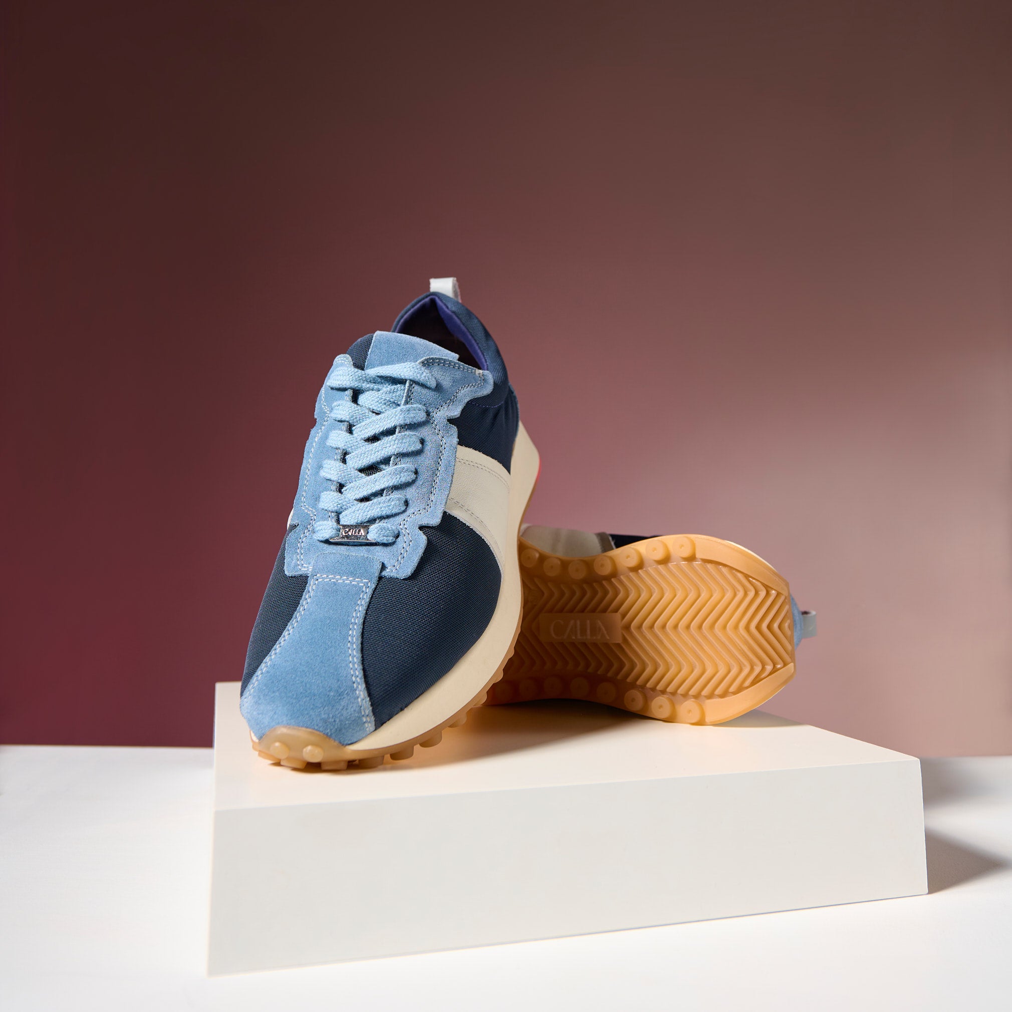 cosmos sneaker on a white platform with a red background