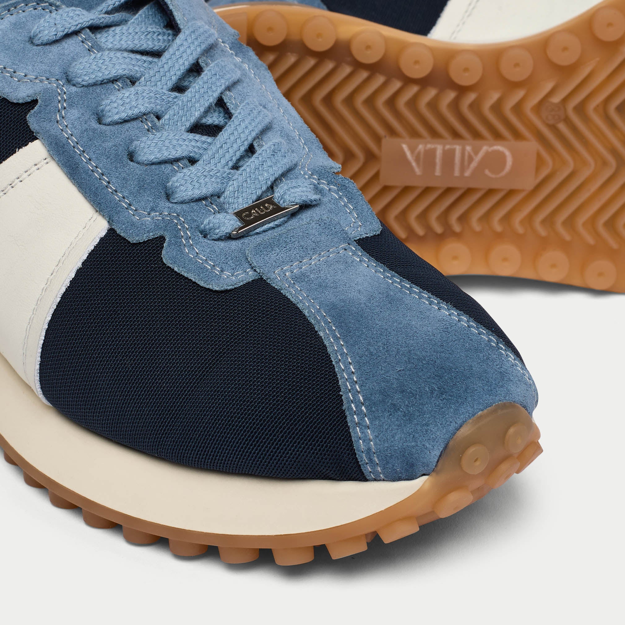 cosmos denim blue sneaker with brown sole on a white background tip close-up