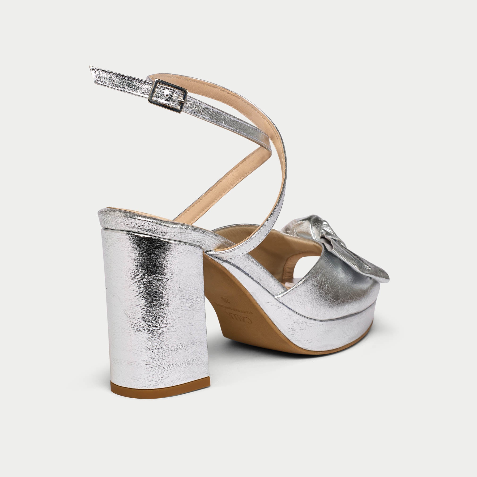 Silver wedge sandals with a strap on a white background