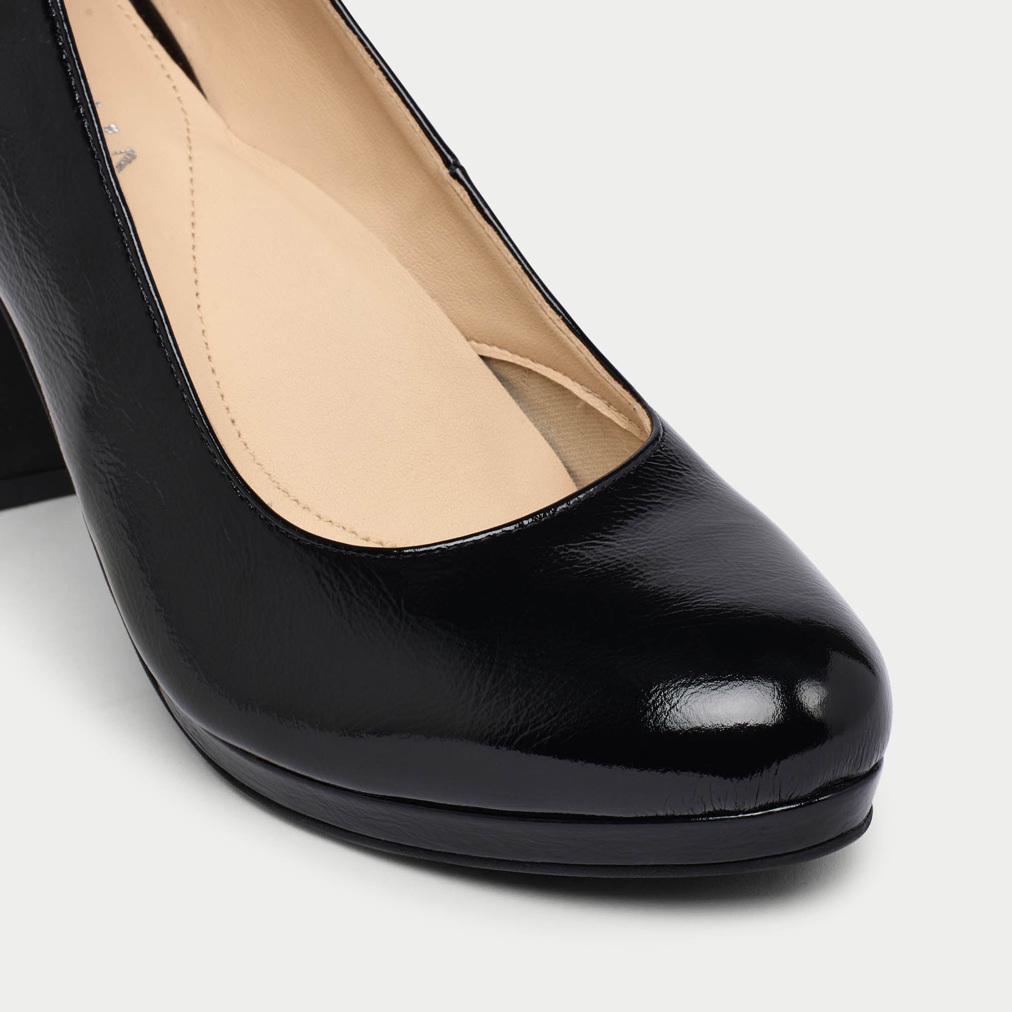 Black patent leather high heel shoe on a white background