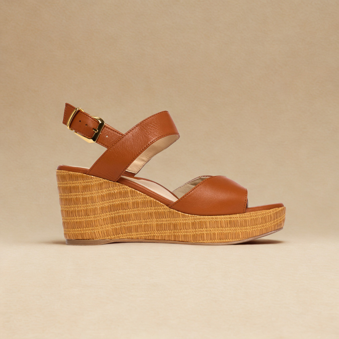 Brown wedge sandal with woven sole on a beige background