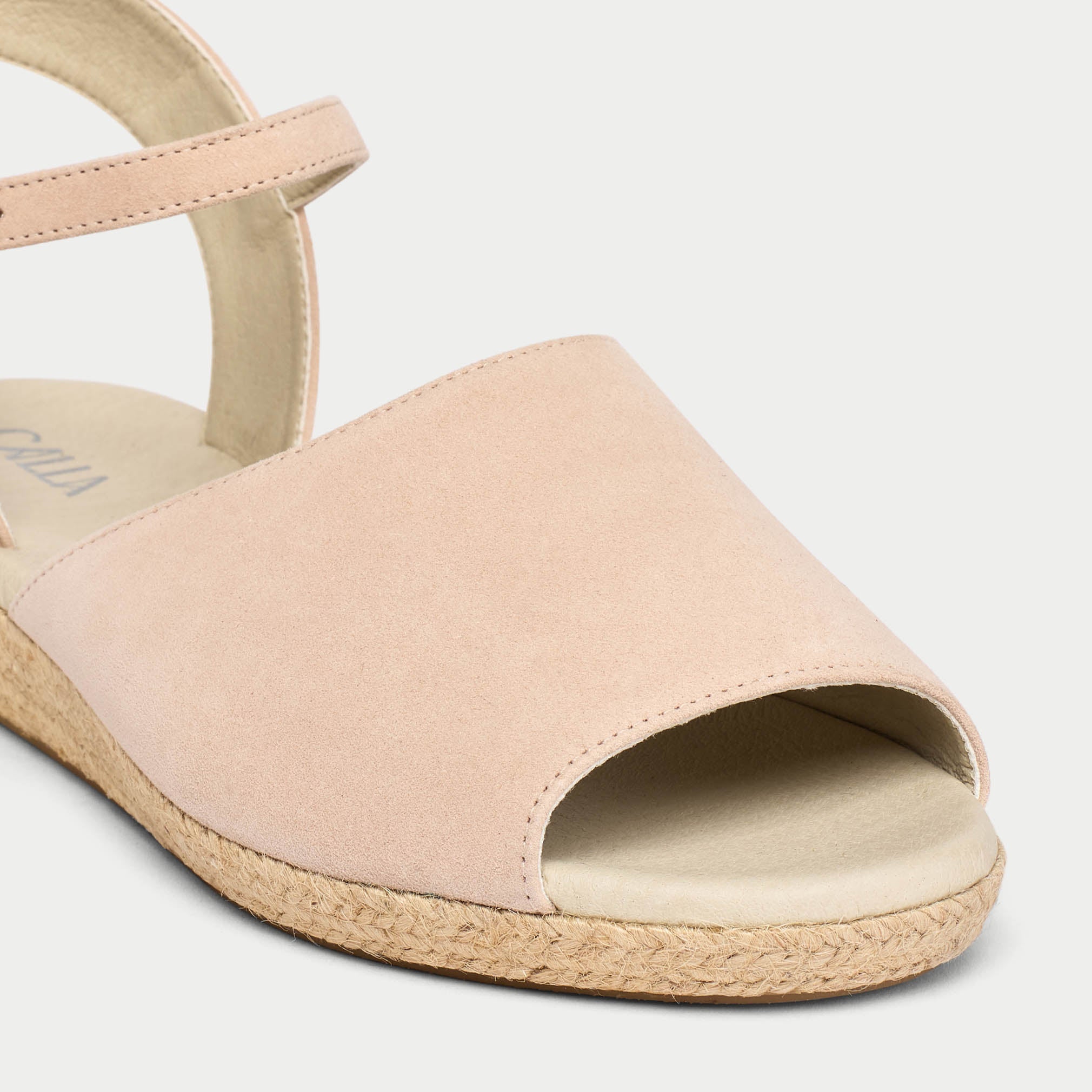 Beige sandal with open toe and textured sole on a light gray background