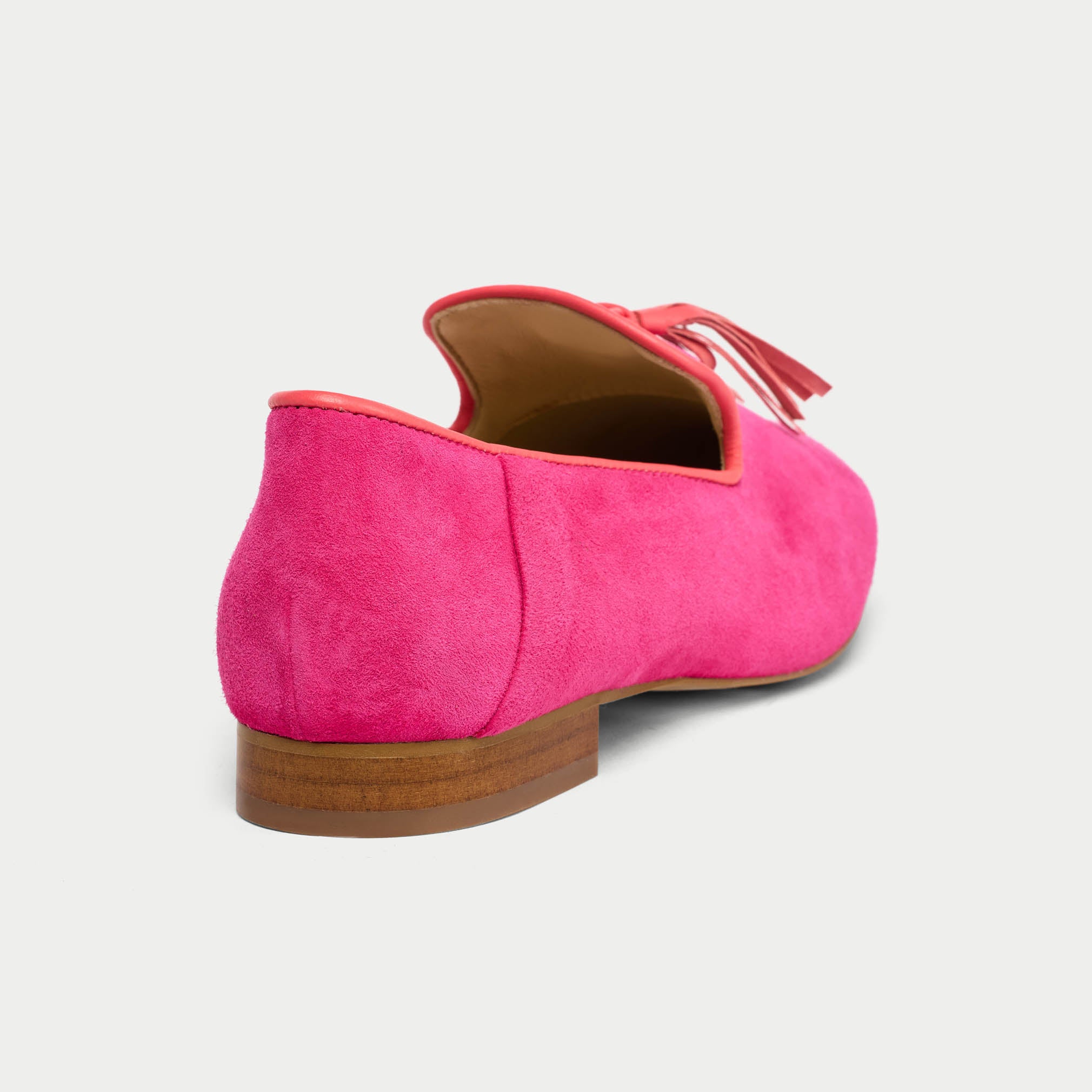 Pink suede loafer shoe on a light gray background