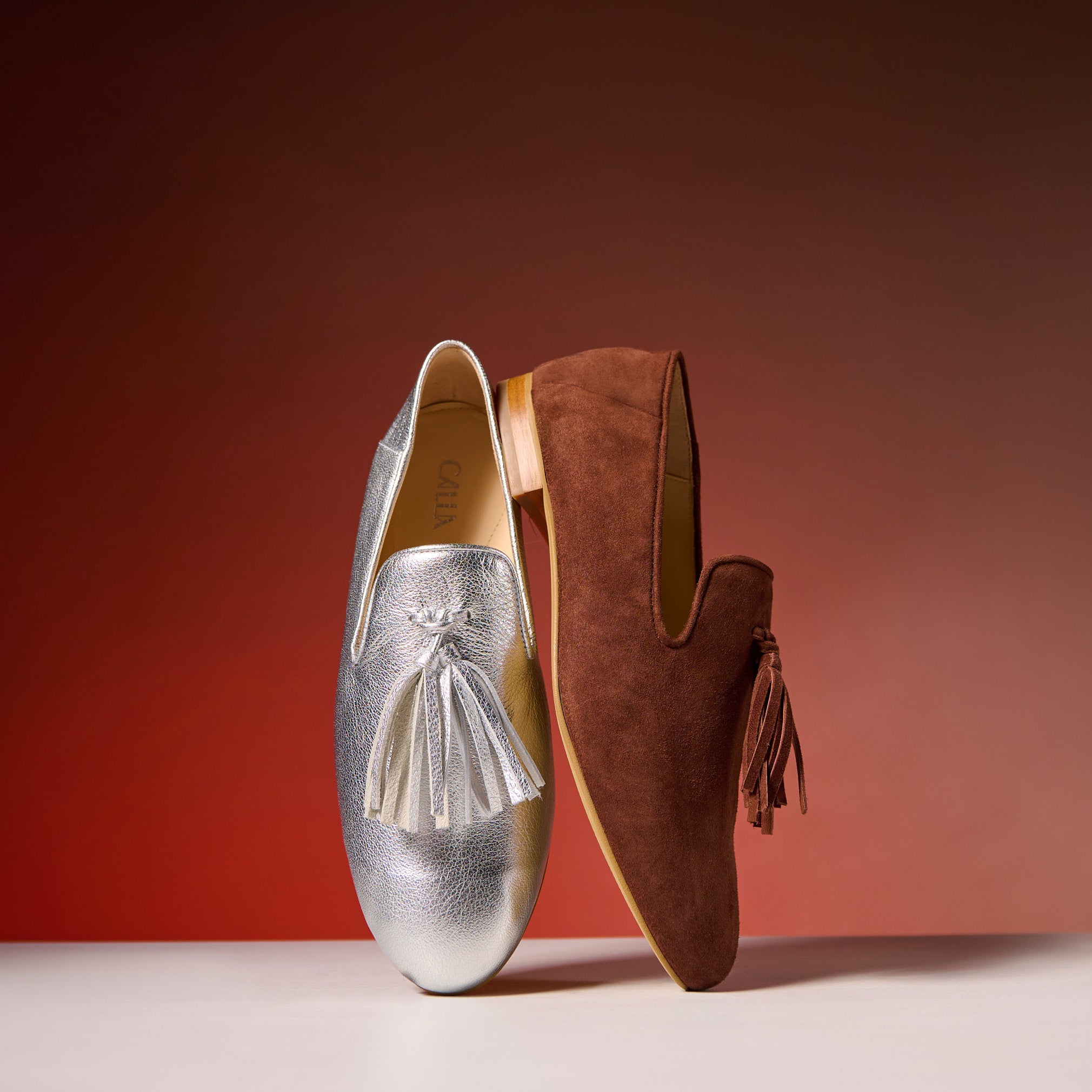 silver and brown loafers on the red background