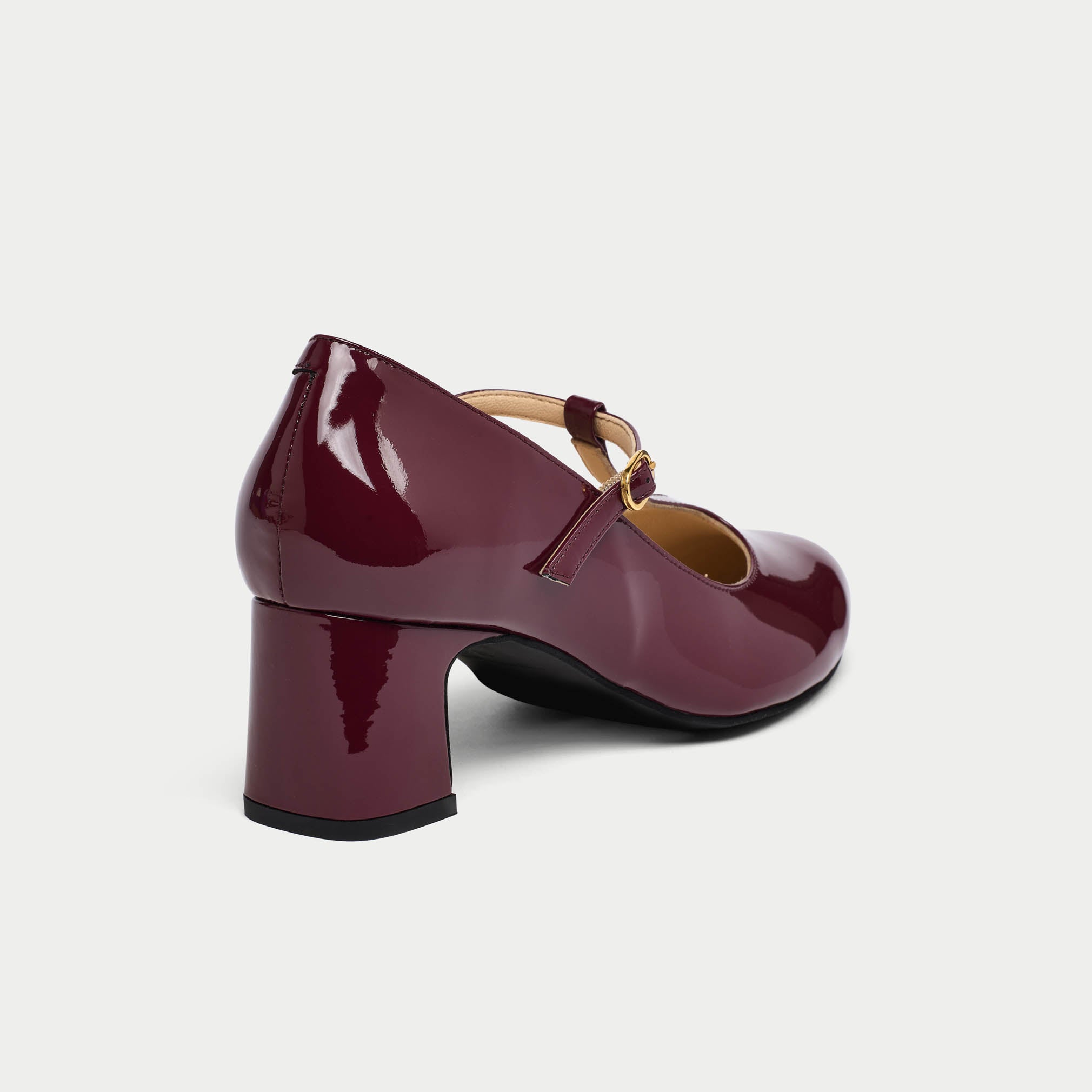 Shiny purple shoe with a block heel on a light gray background