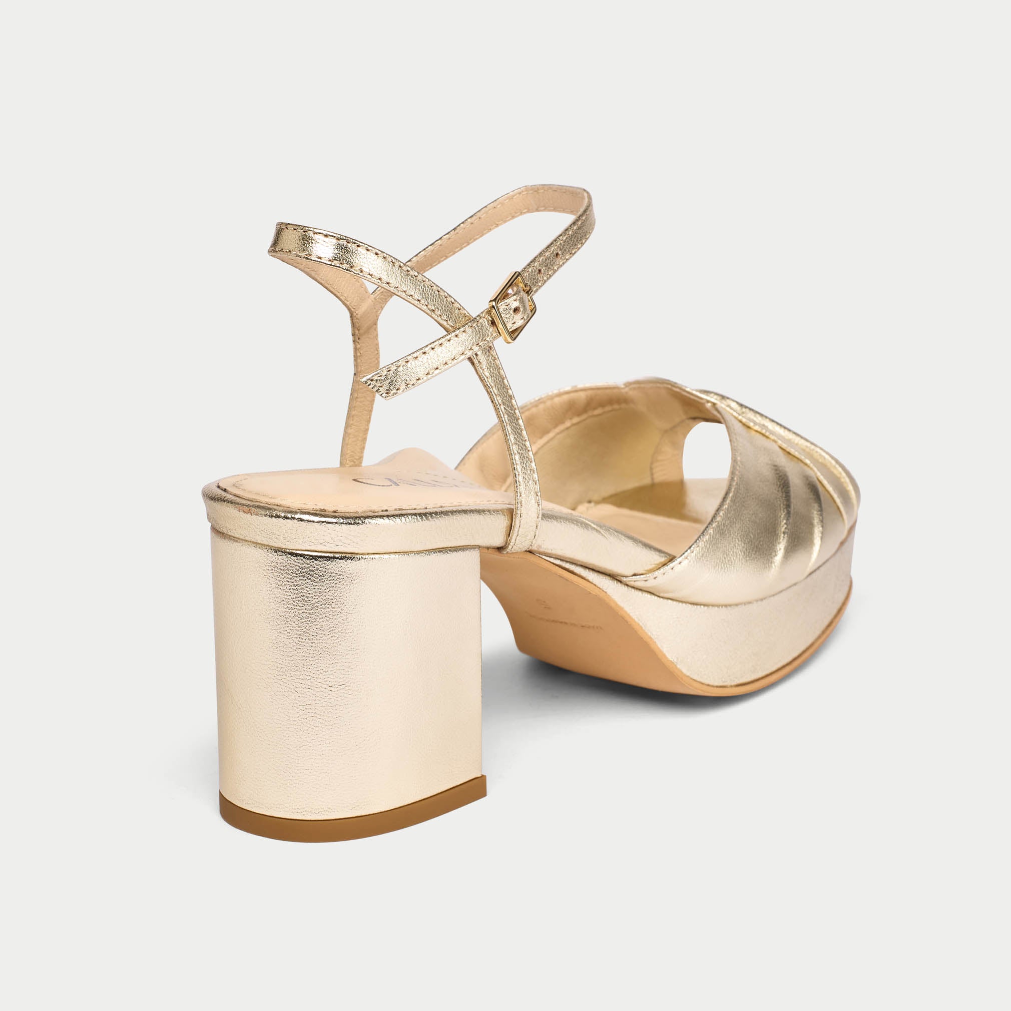 Gold high-heeled sandal on a light gray background