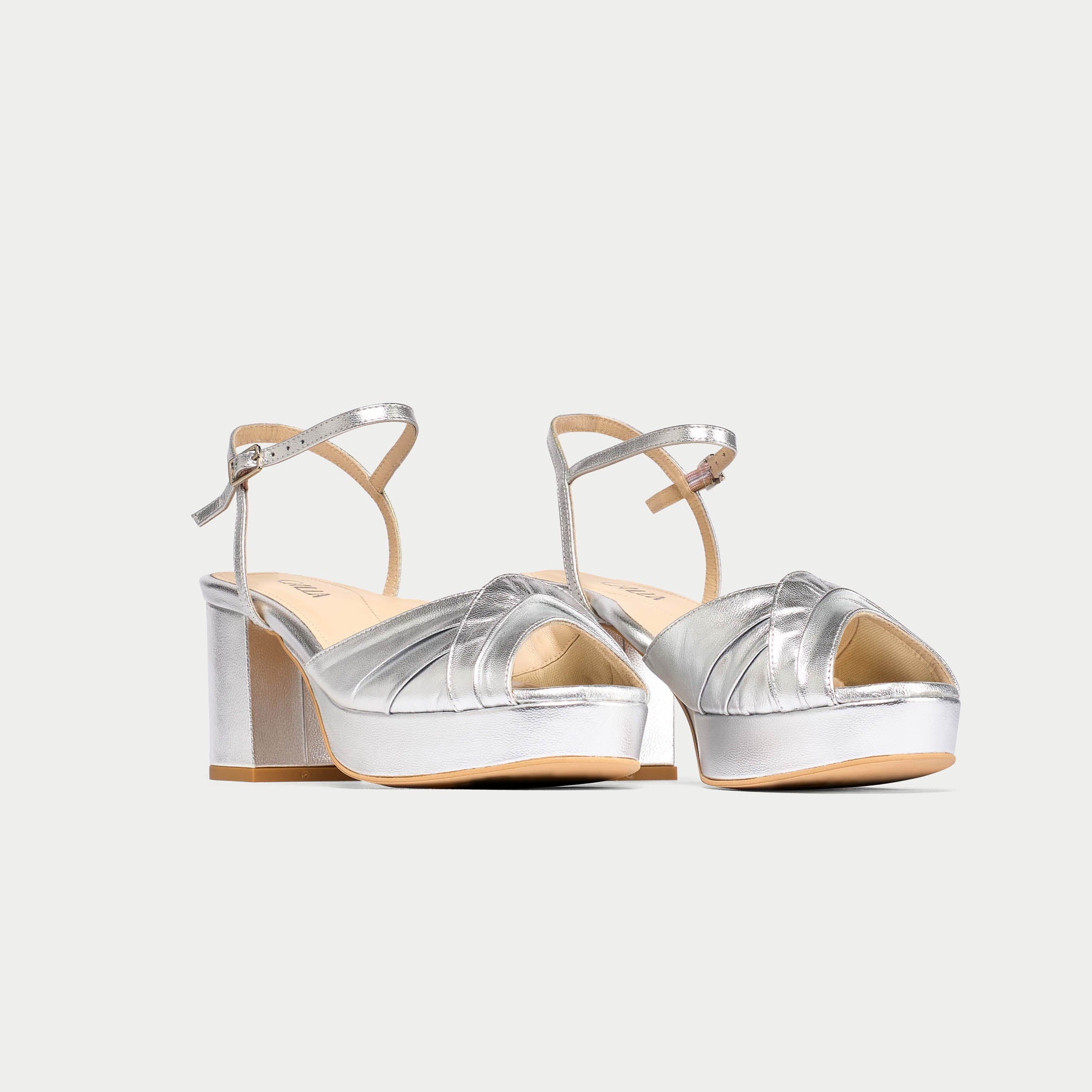 Silver high-heeled sandals on a white background