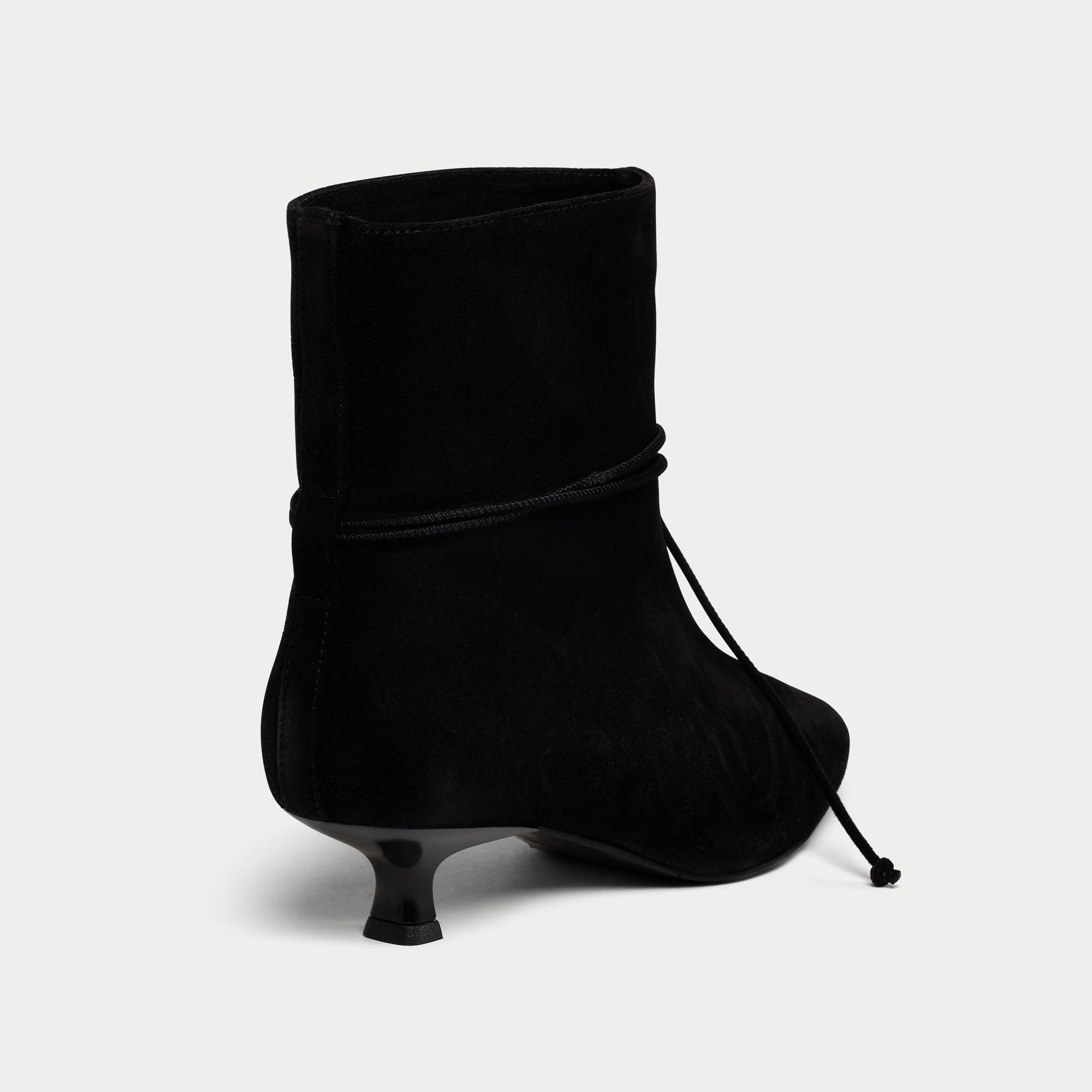 Black ankle boot with a thin heel on a light gray background
