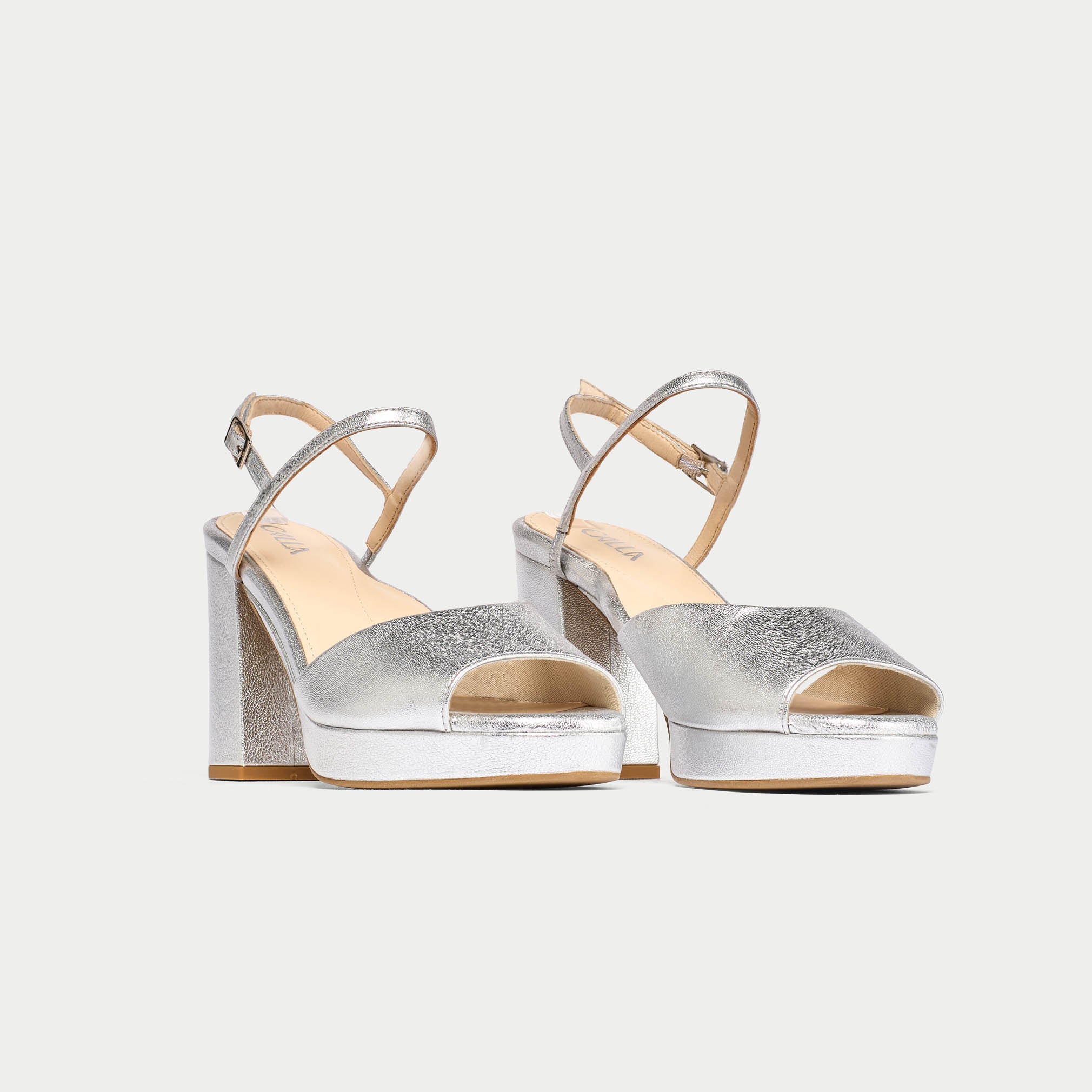 Pair of silver high-heeled sandals on a white background