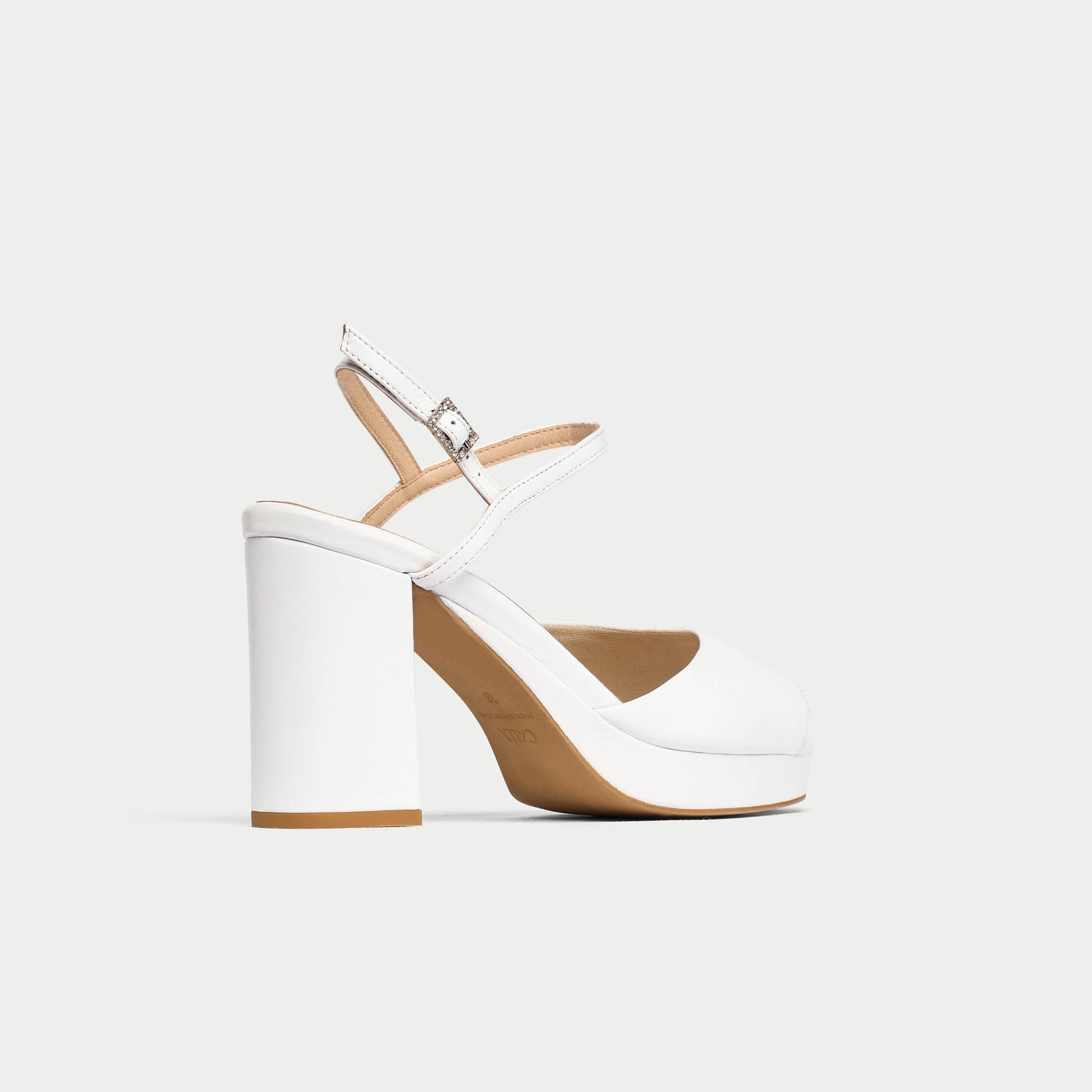 White sandal with a block heel on a light gray background