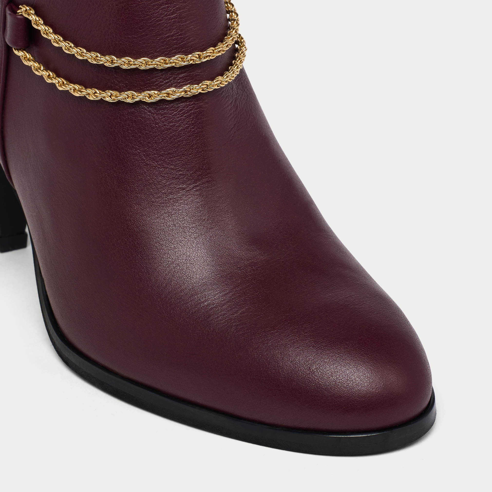 Maya cherry ankle boot with gold chain detail on a white background tip close-up