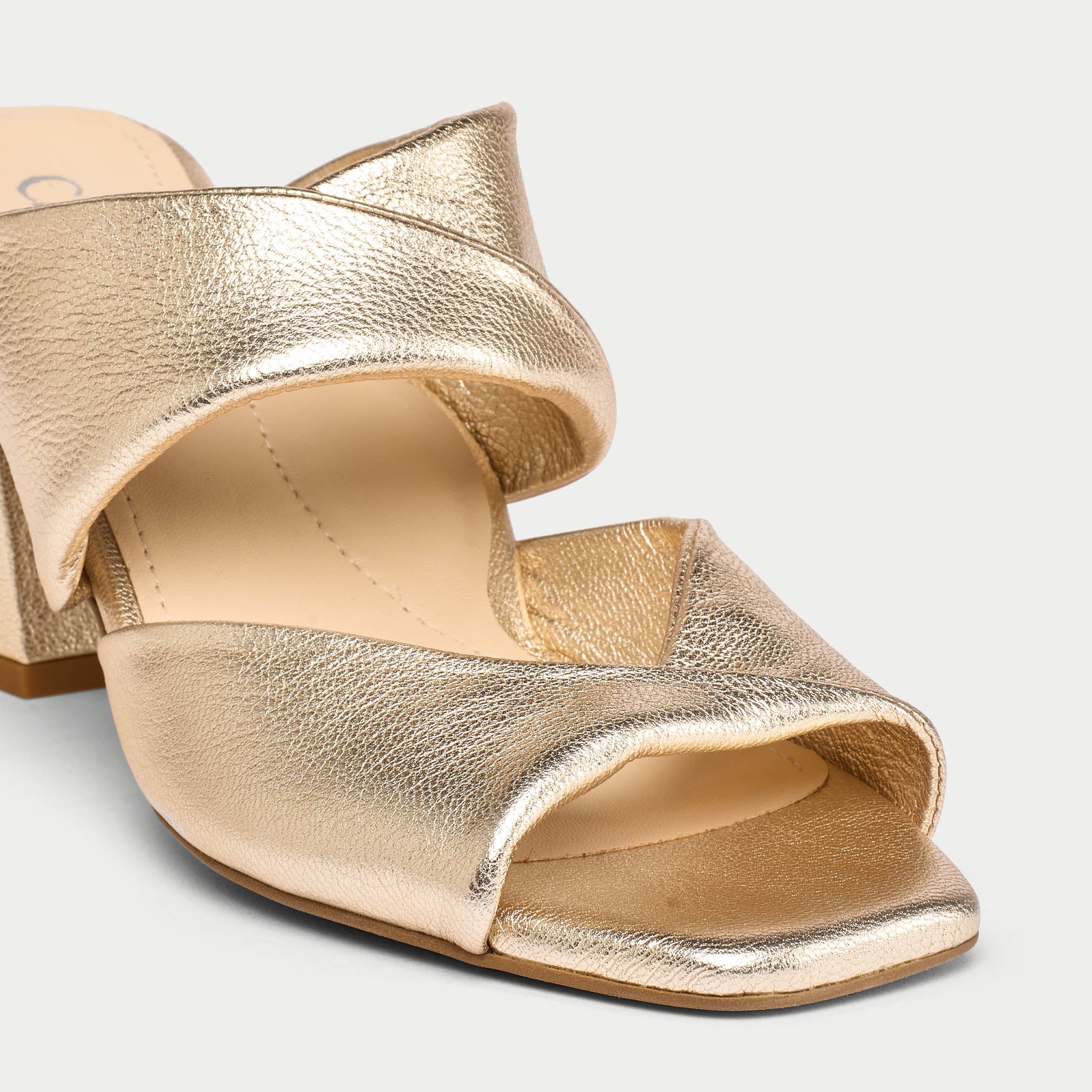 Gold open-toe sandals on a light gray background