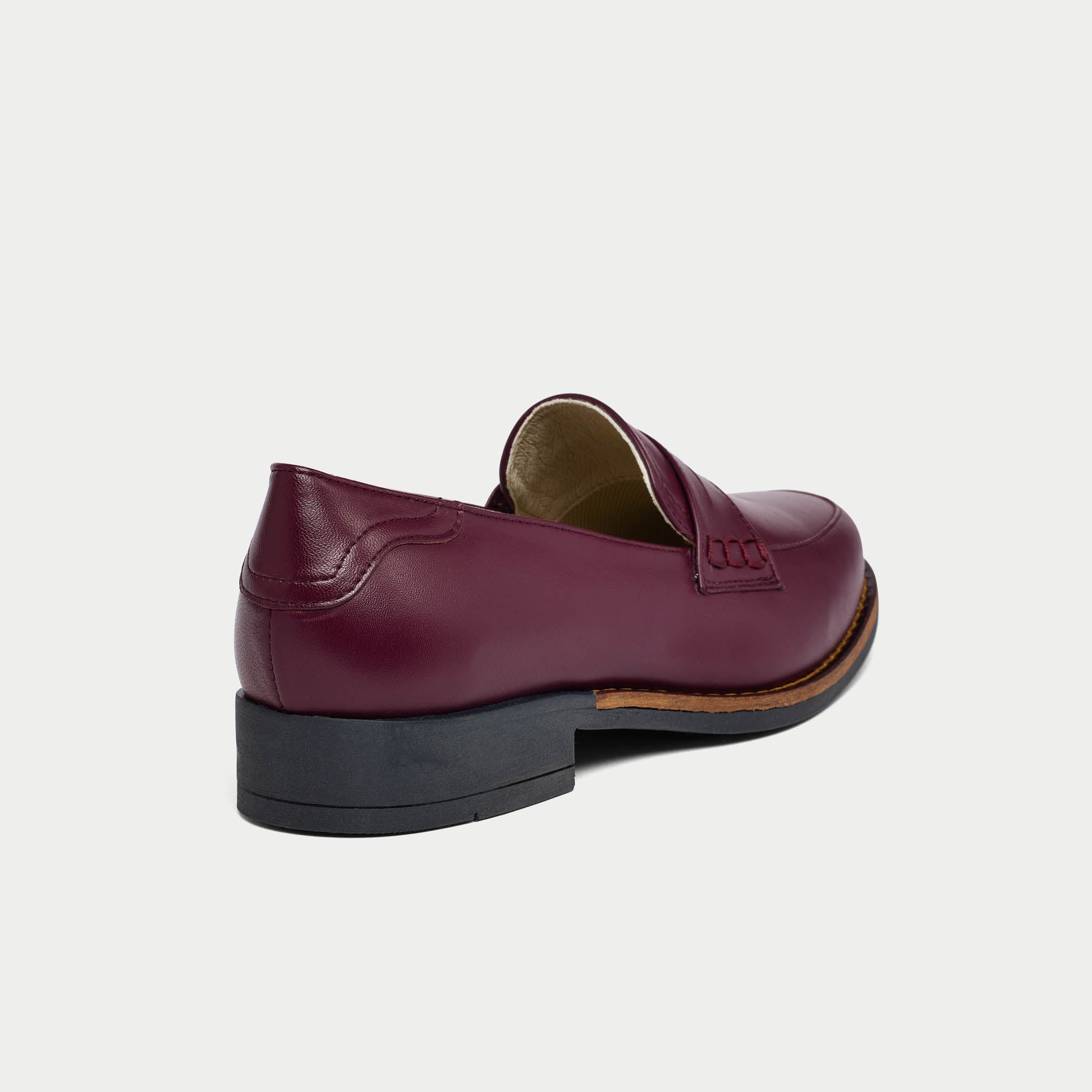 cherry Nadia loafer shoe on a light gray background heel close-up