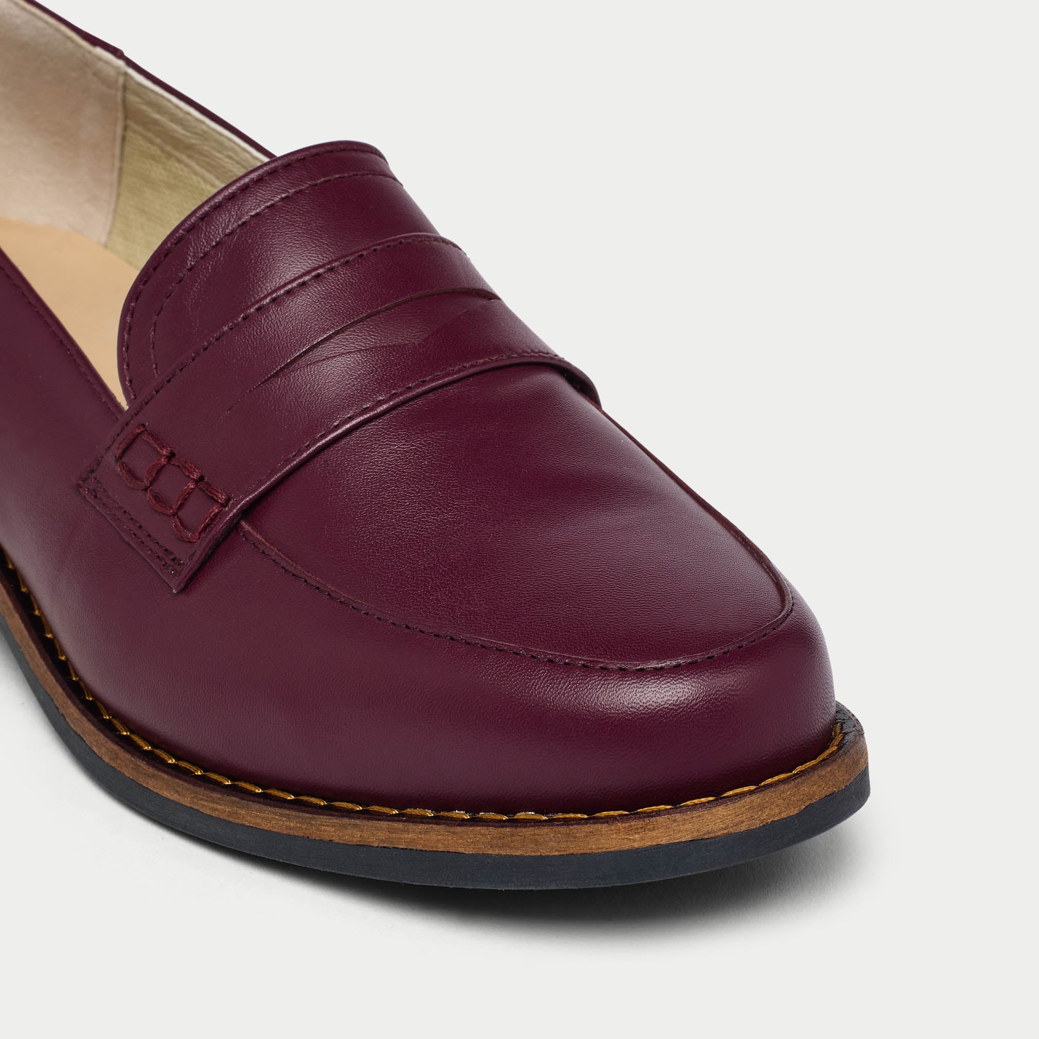cherry Nadia loafer shoe on a light gray background tip close-up