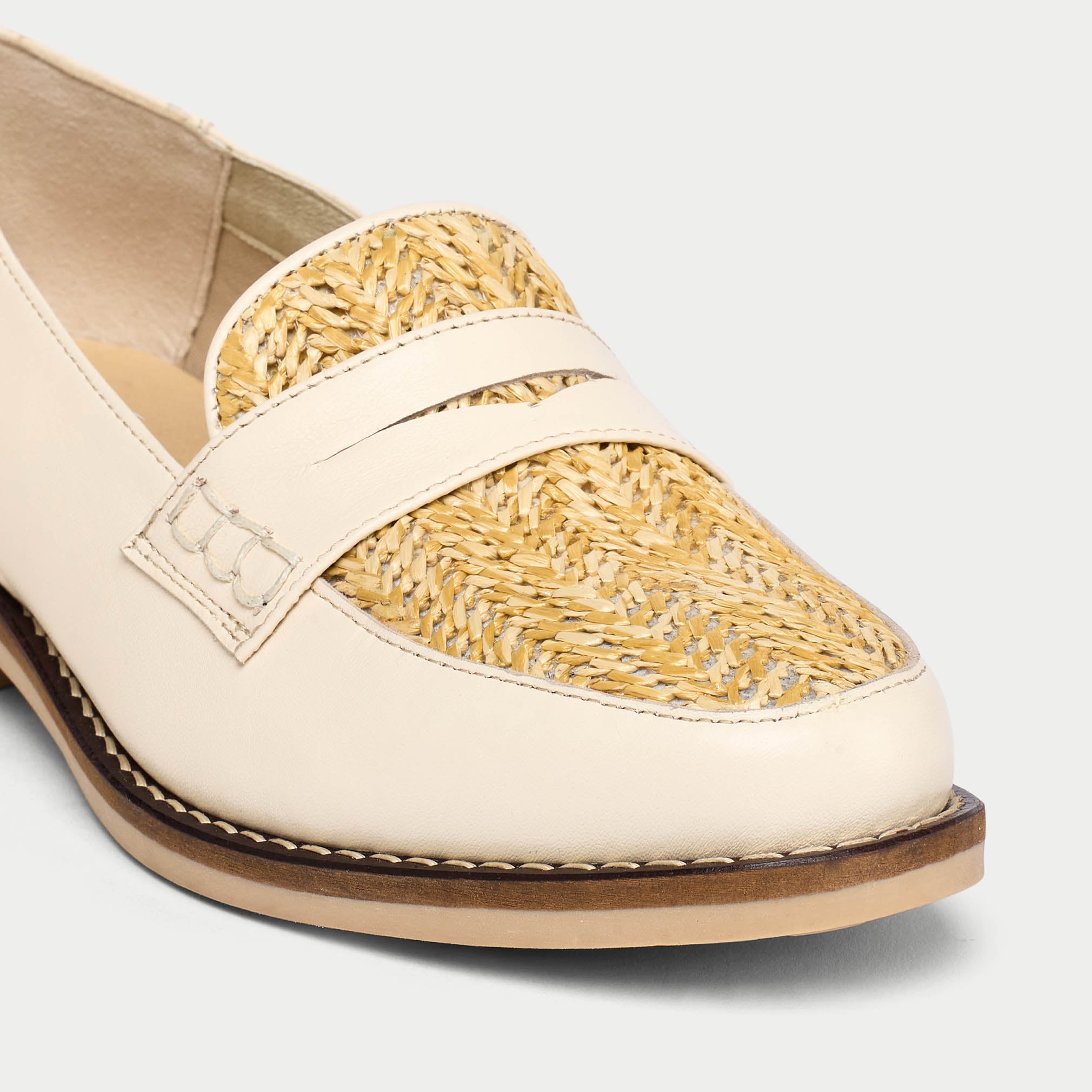 Loafer shoe with beige leather and woven pattern on a white background