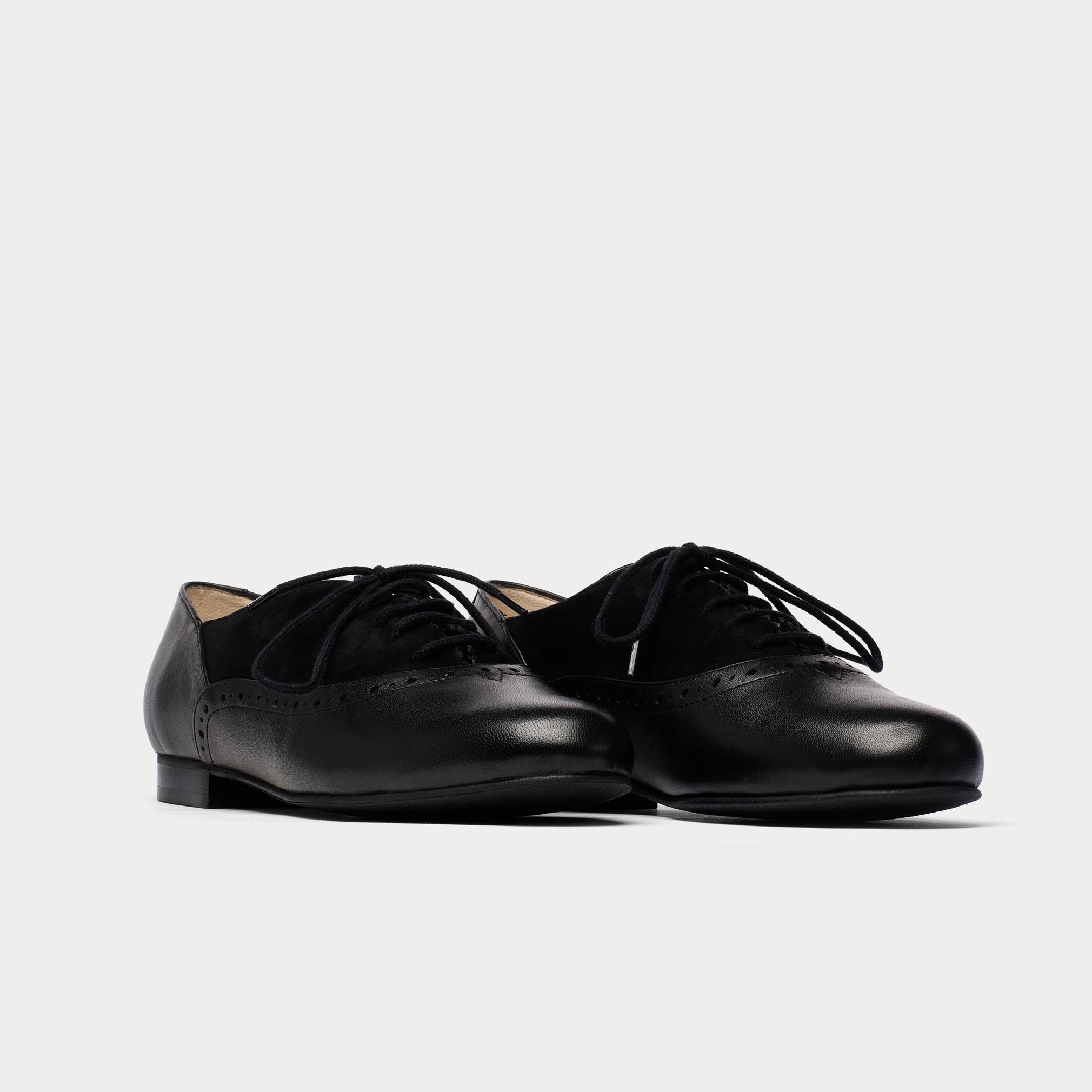 Pair of black leather shoes on a light gray background