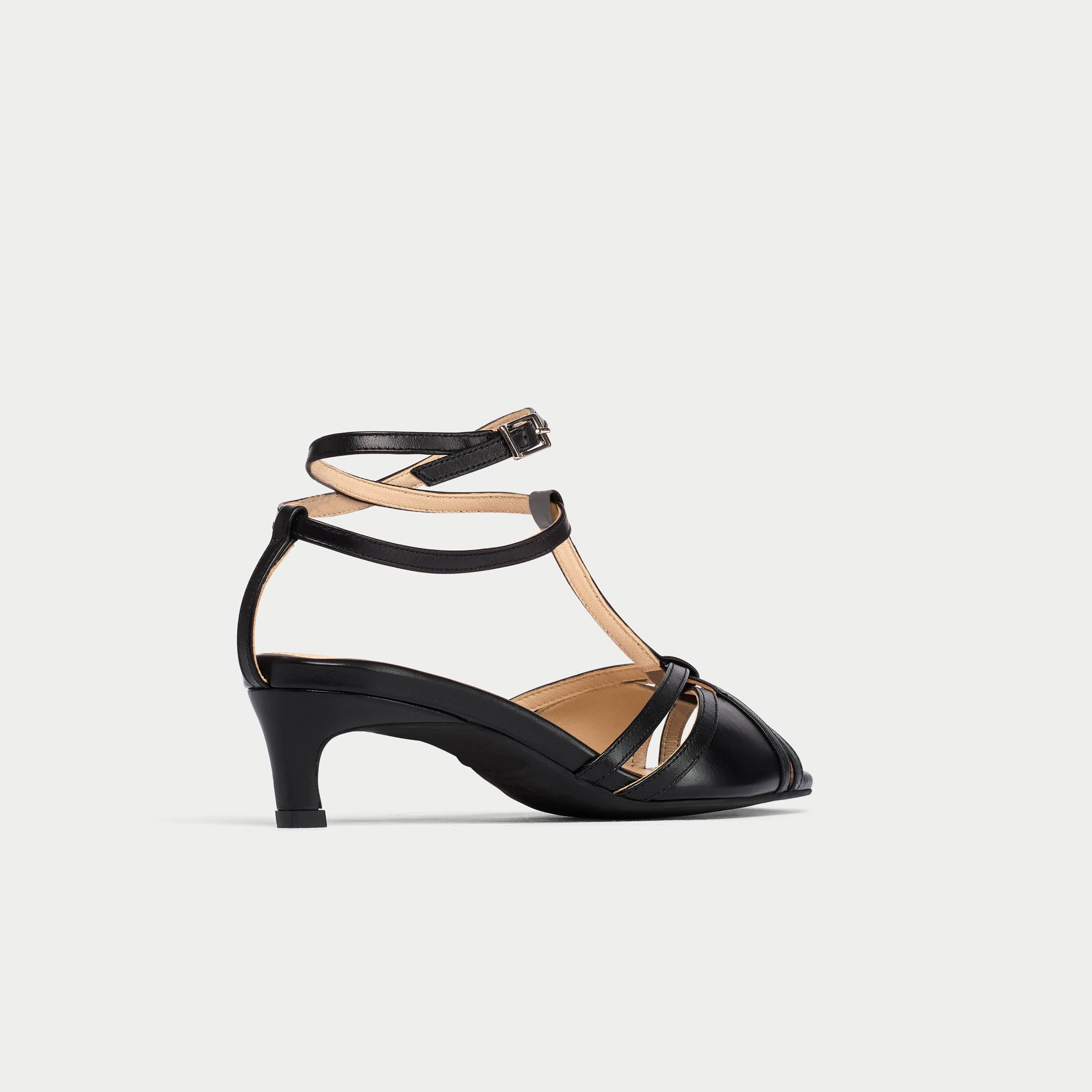 Black sandal with a thin strap on a light gray background