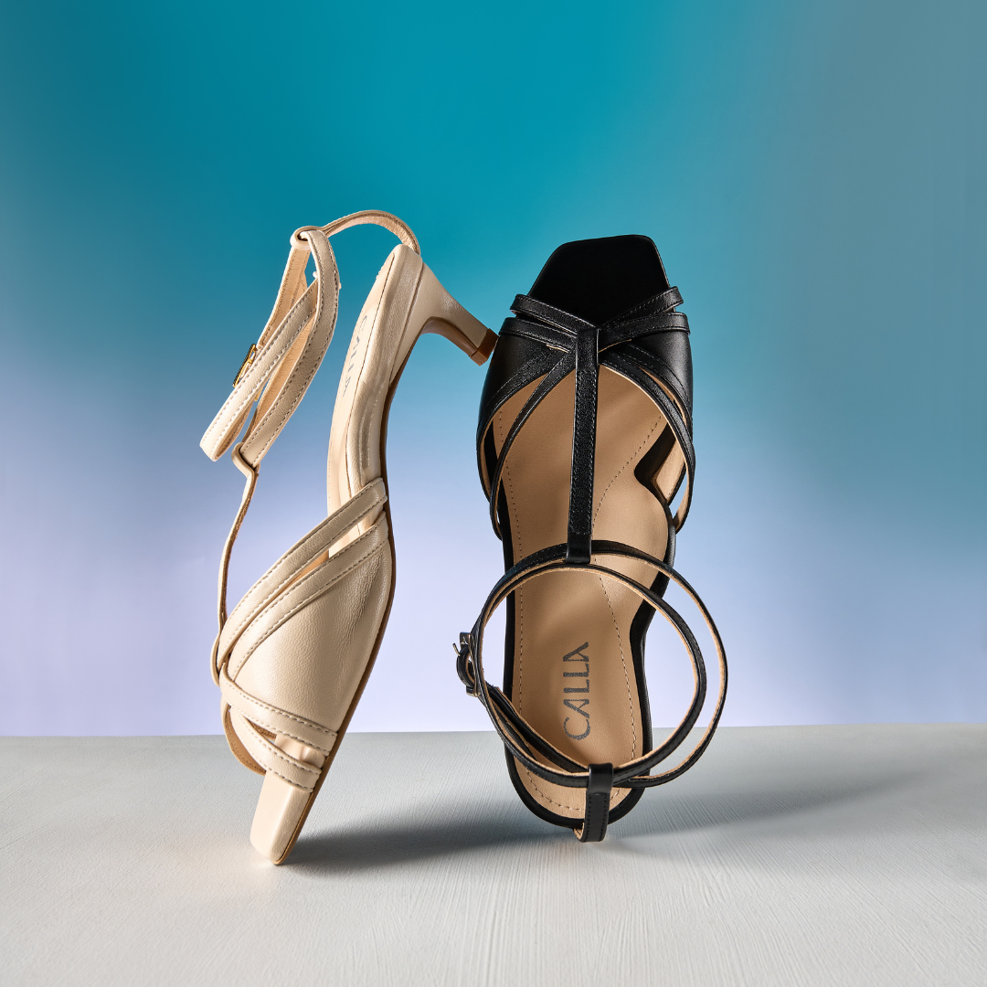 Pair of kitten-heeled sandals on a gradient background