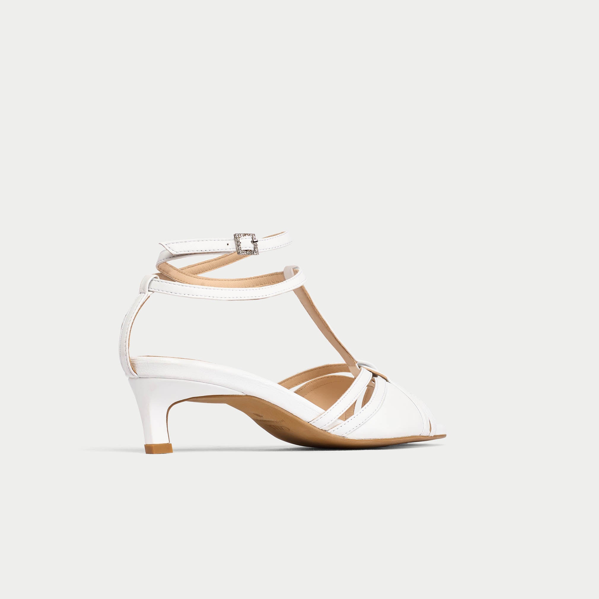 White sandal with ankle strap on a light gray background