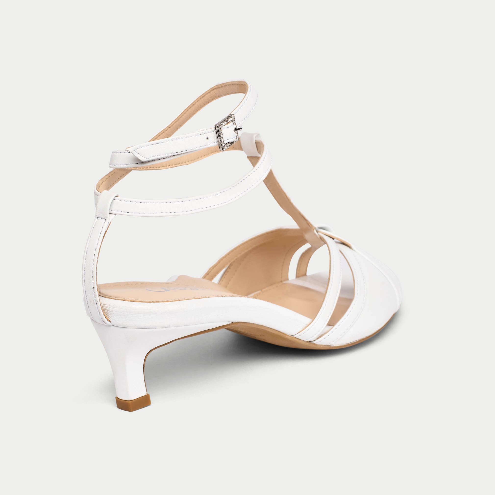 White sandal with a thin strap on a light gray background