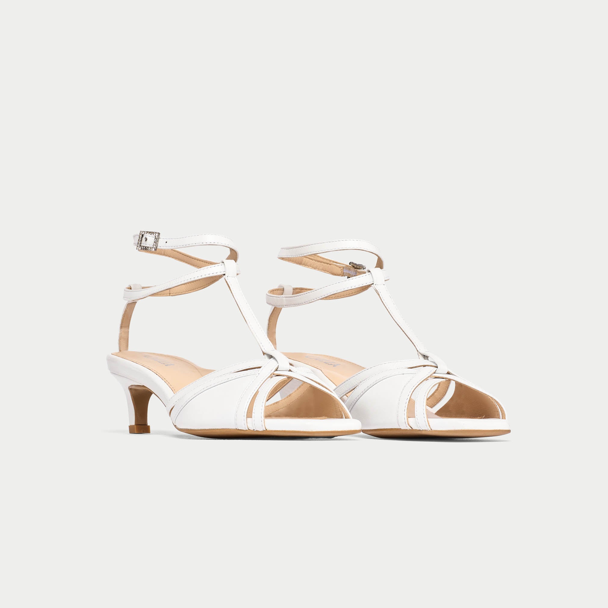 White strappy sandals on a light gray background