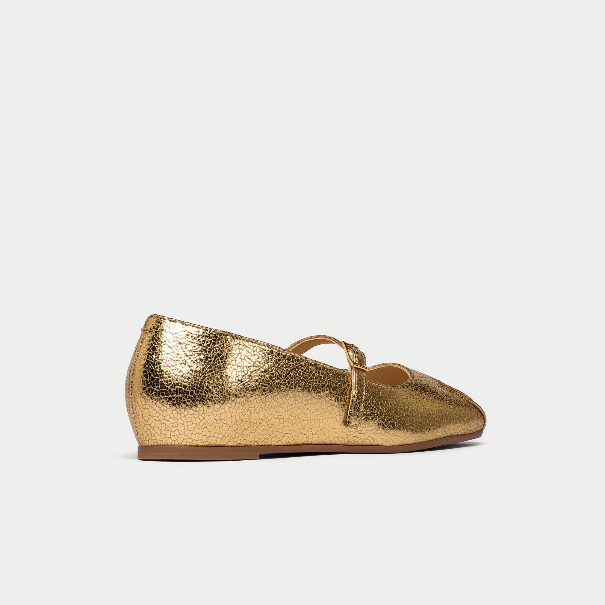 Gold metallic flat shoe on a light gray background