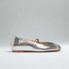 Silver metallic flat shoe with a strap on a gray background