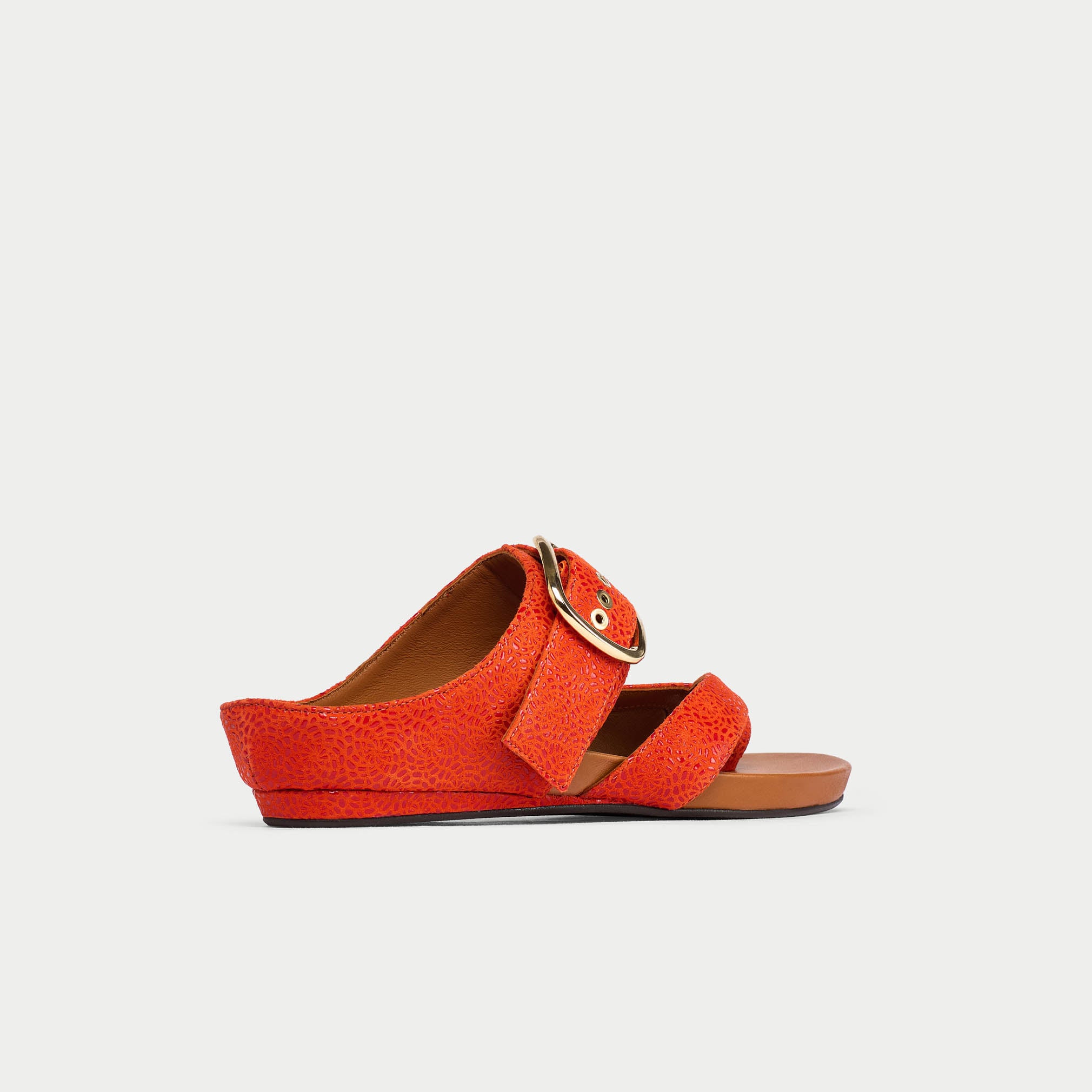 Orange sandal with a strap and buckle on a light gray background