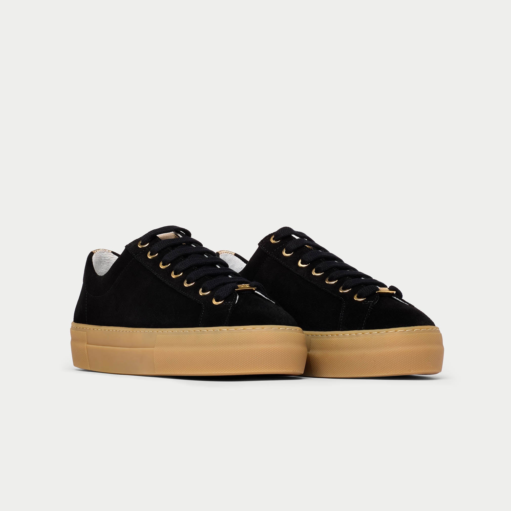 Black Saturn sneakers with tan soles on a light gray background