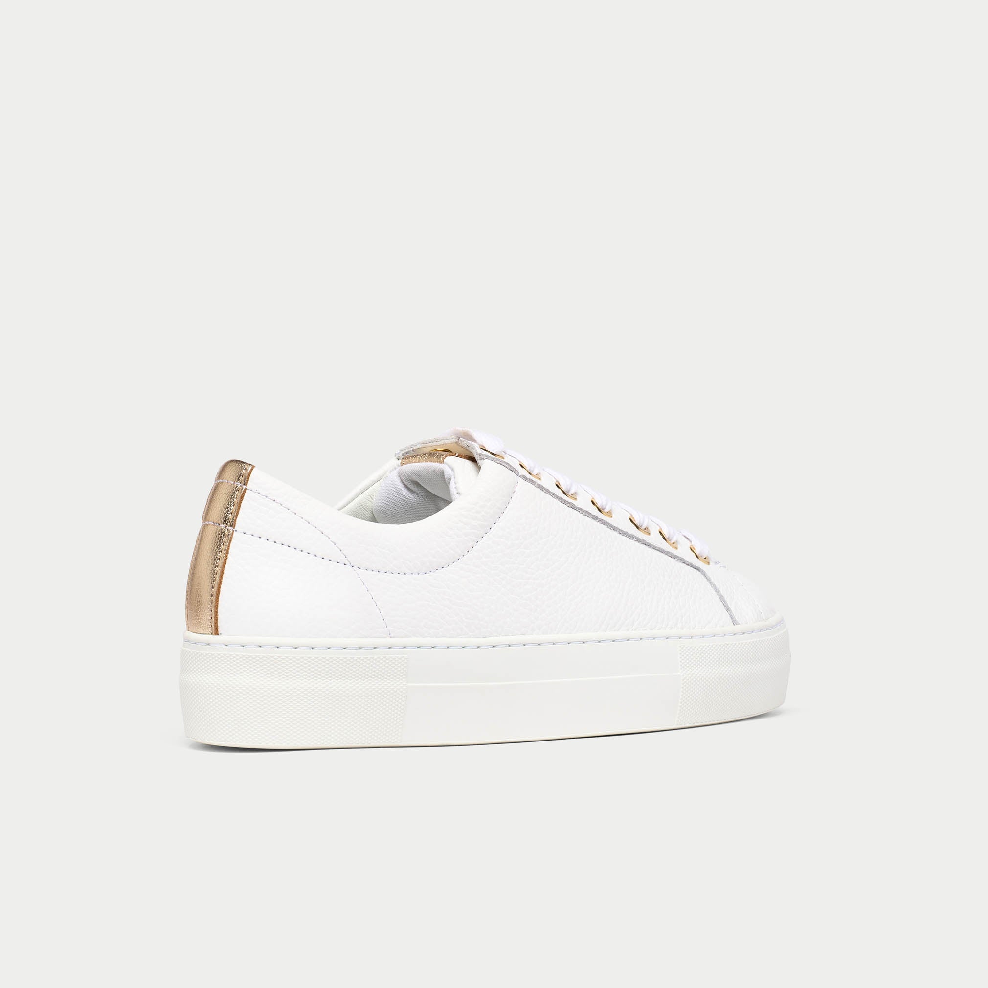 White saturn sneaker with gold accents on a white background