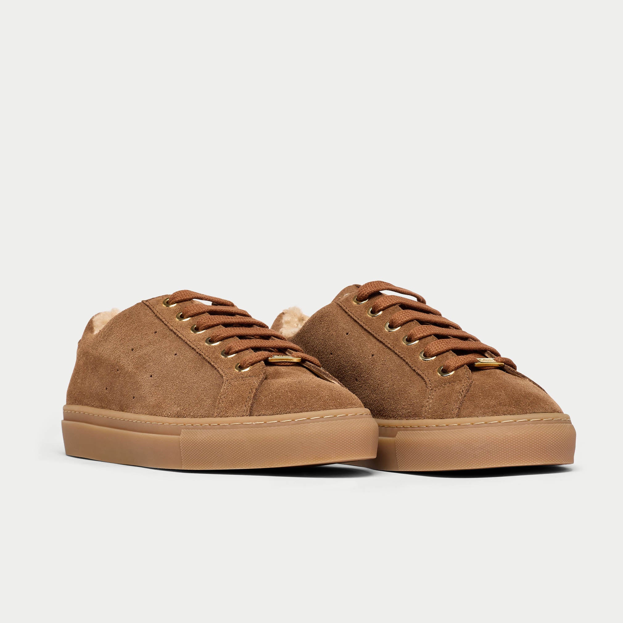 Pair of brown suede sneakers on a light gray background