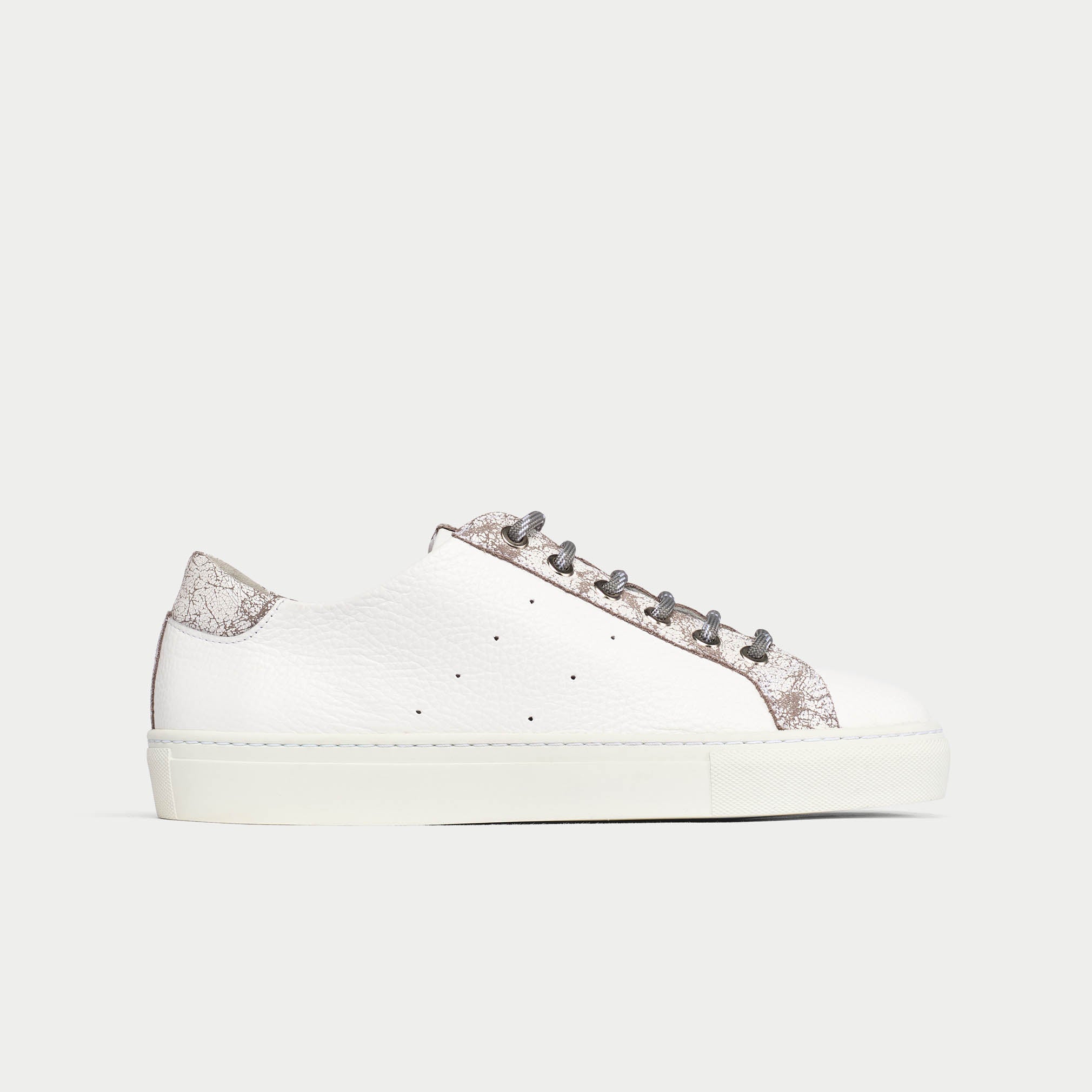 White sneaker with decorative elements on a white background