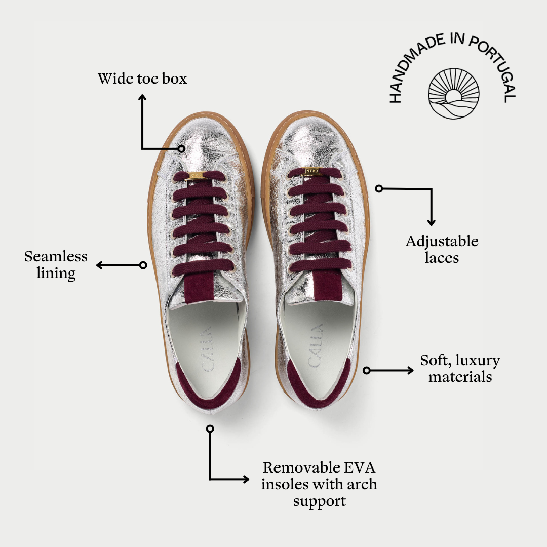 Silver sneakers with burgundy laces on a white background, featuring text labels about shoe features.