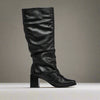 Black knee-high boot on a light gray background
