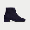 Navy blue ankle boot on a light gray background