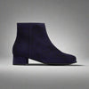 Navy blue ankle boot on a light gray background