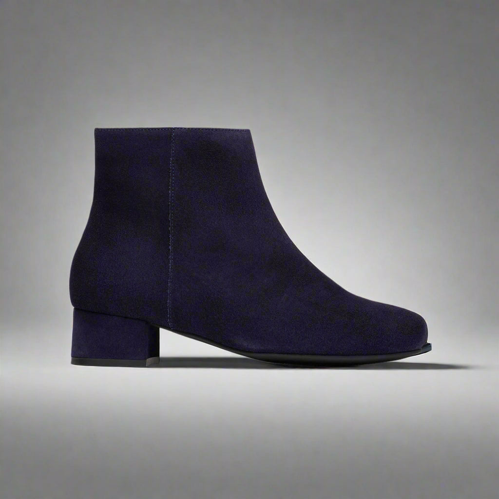 Navy blue ankle boot on a light gray background
