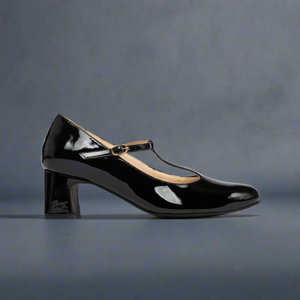 Black patent leather shoe with a strap on a navy background