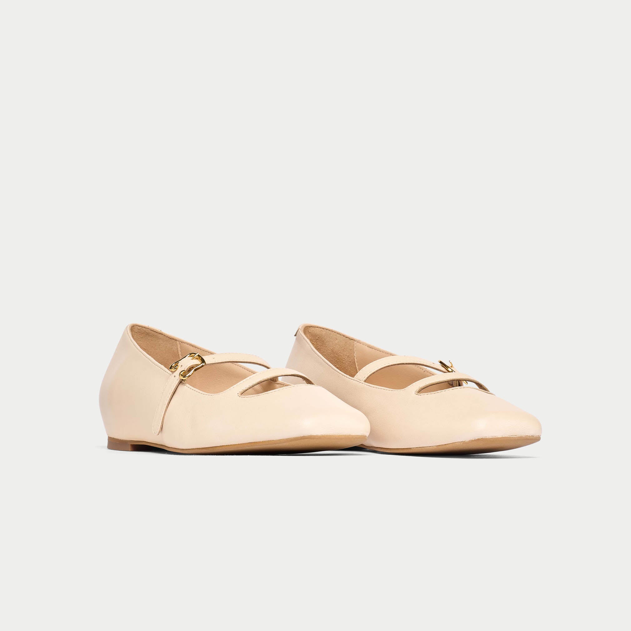 Pair of beige flats on a light gray background
