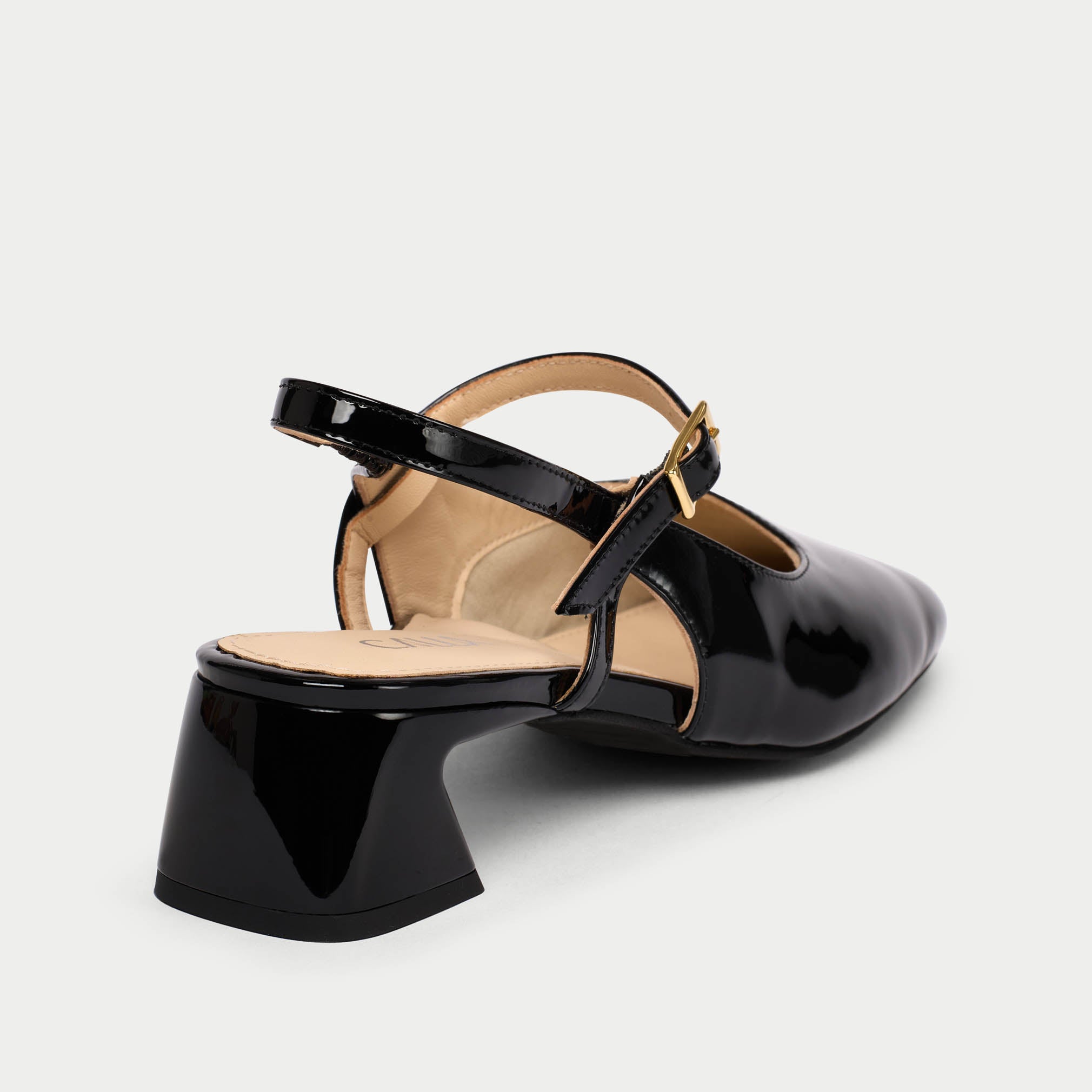 Black patent leather shoe with a slingback design on a white background