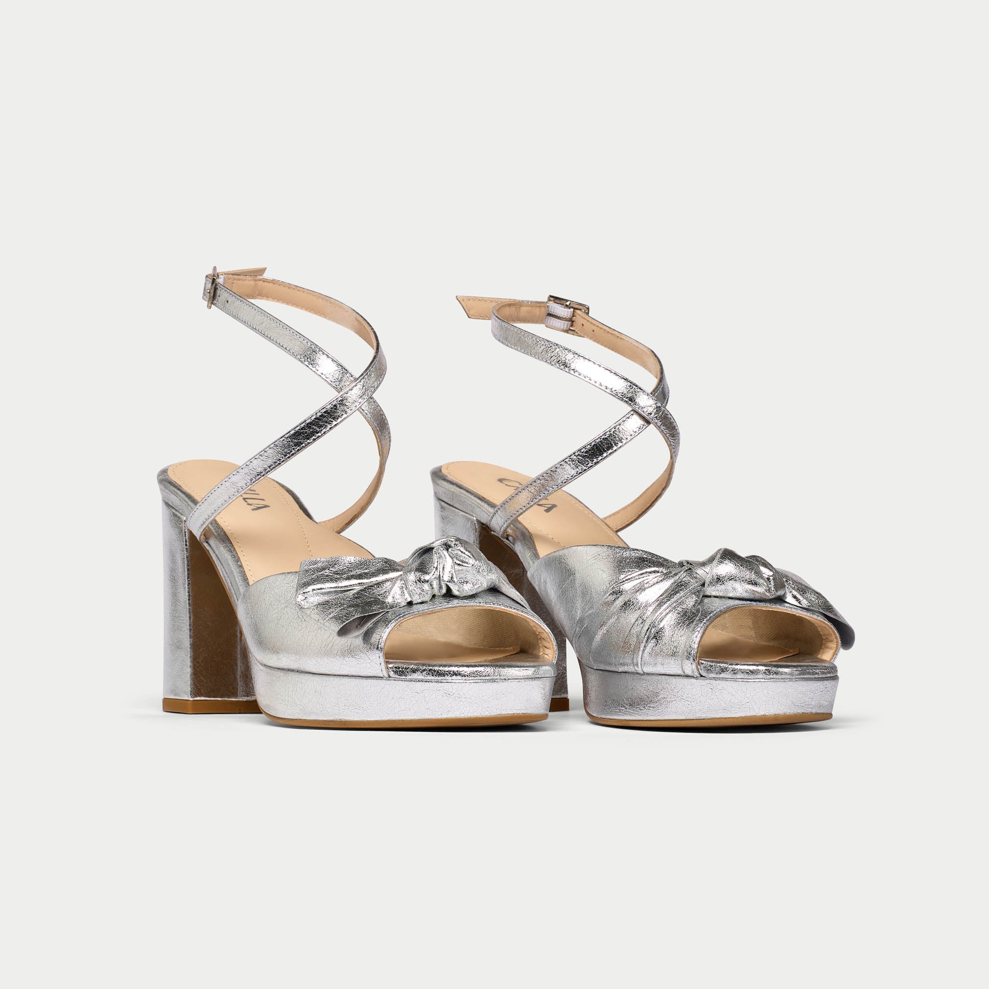 Pair of silver high-heeled sandals on a white background