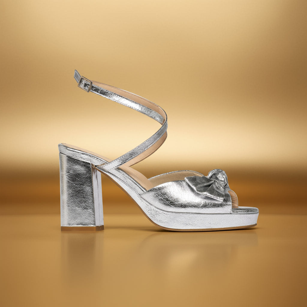 Silver high-heeled sandal on a gold background