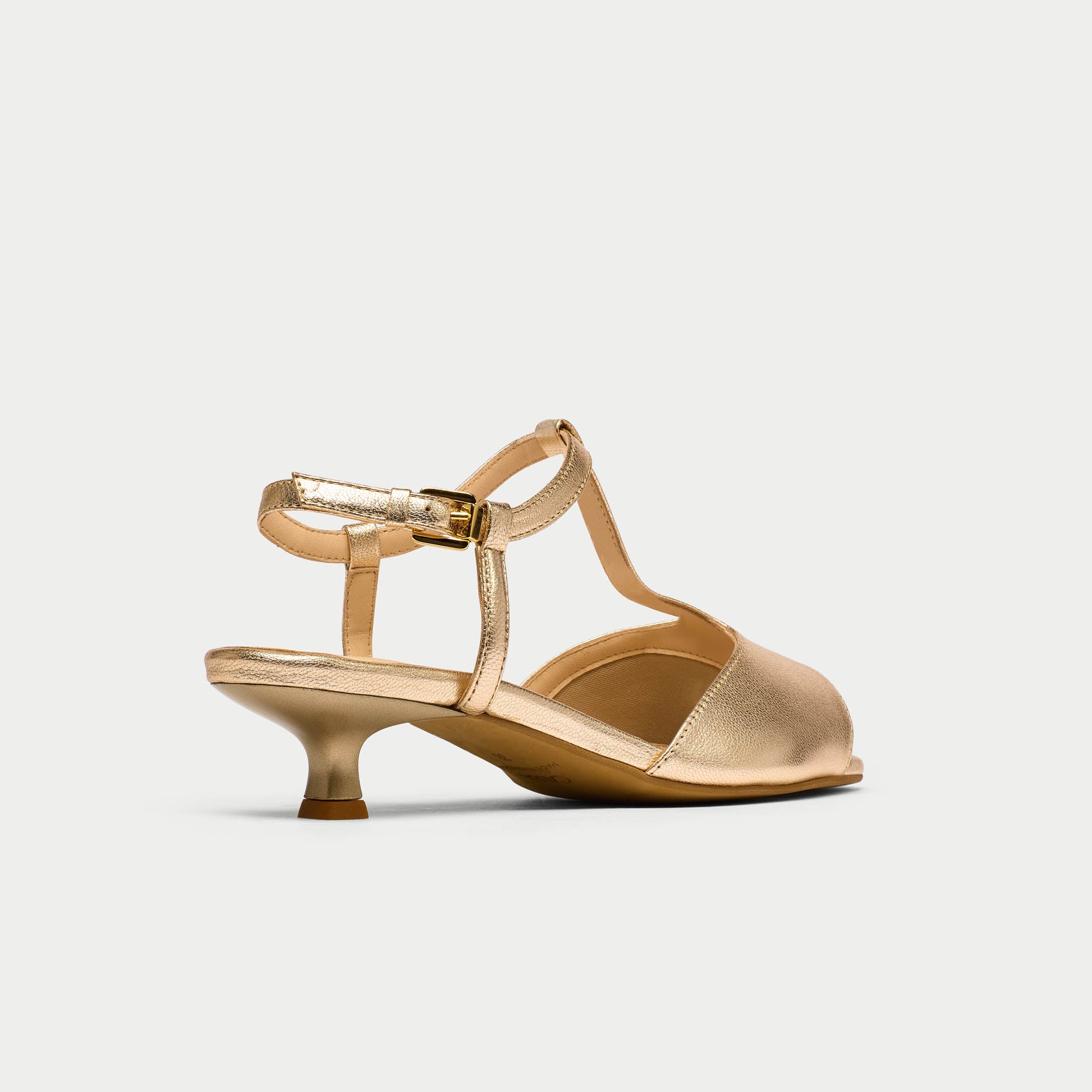 Gold high-heeled shoe on a light gray background