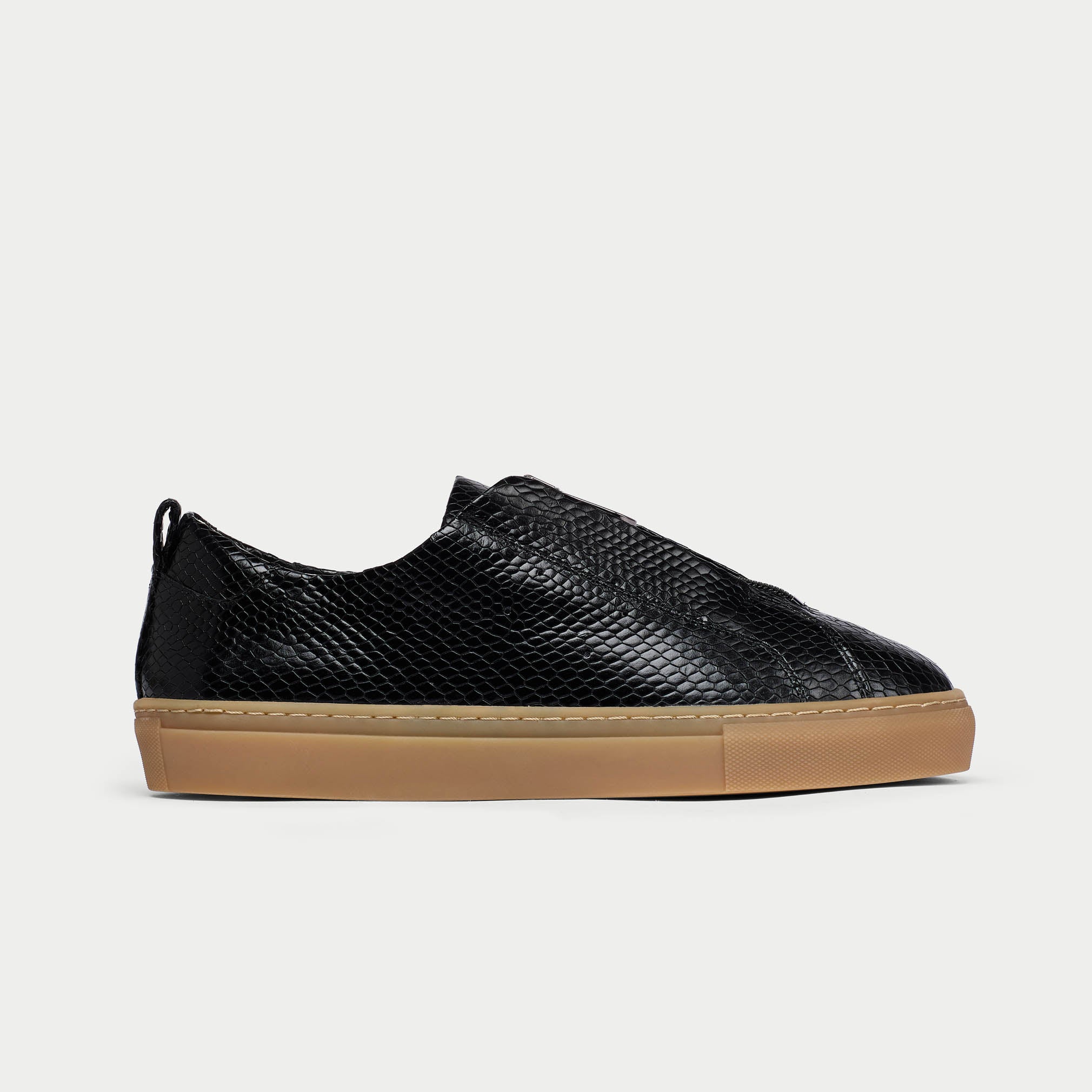 Black Estella sneaker with a brown sole on a light gray background side view
