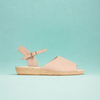 Beige sandal with a jute wedge sole on a light blue background